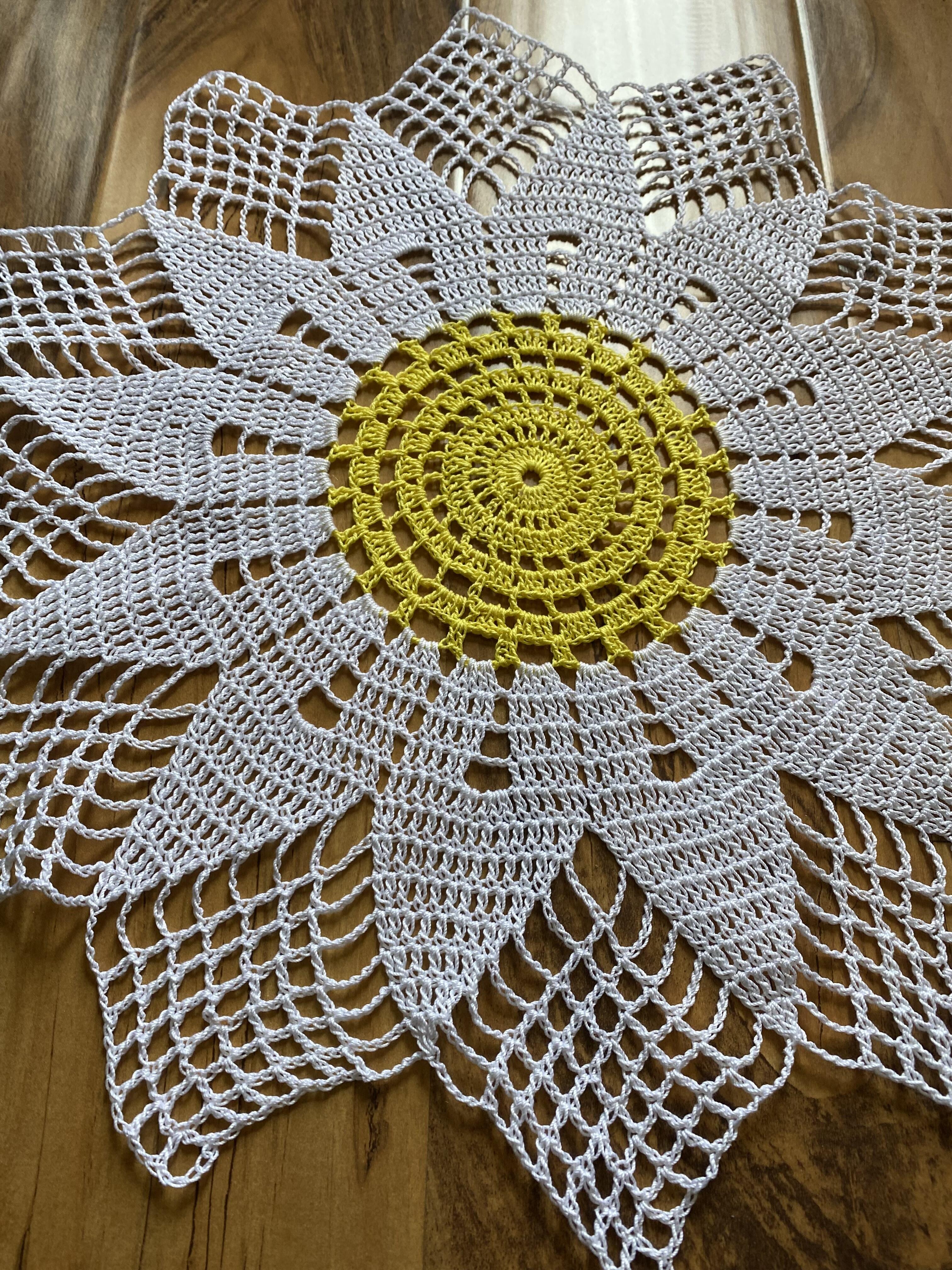 Daisy doily with bright yellow center and white petals