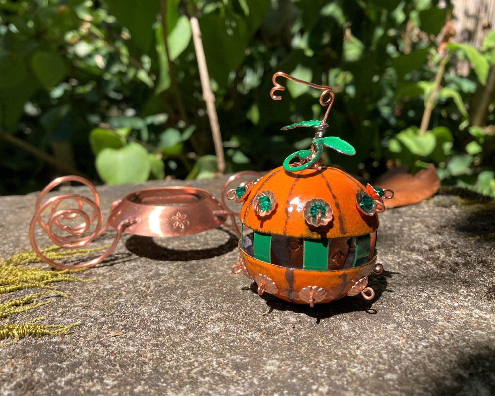 miniature pumpkin carriage made of copper enamel and copper wire showing how pumpkin comes off of chassis