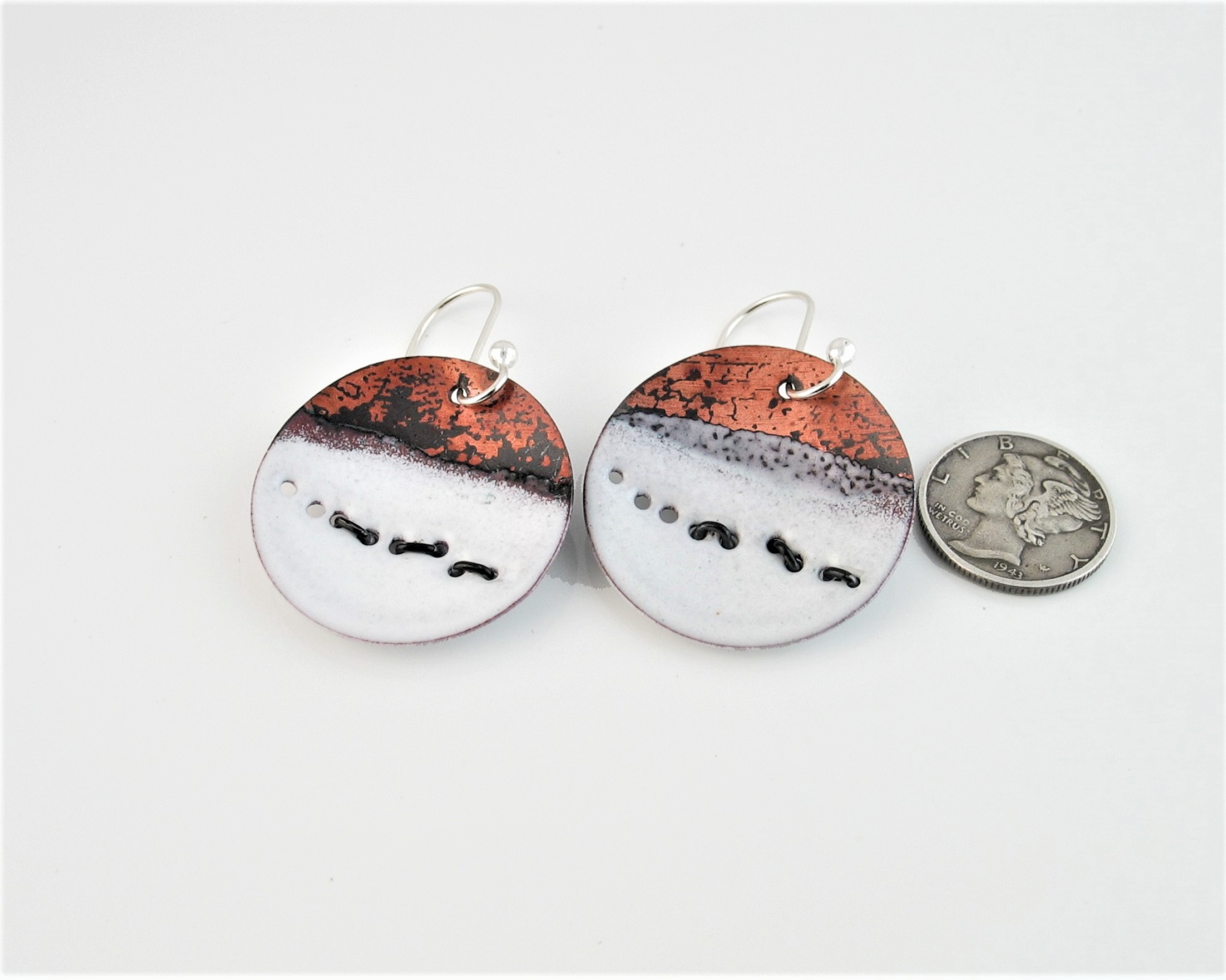 flame painted and white enameled copper earrings with blackened sterling wire representing running wolves