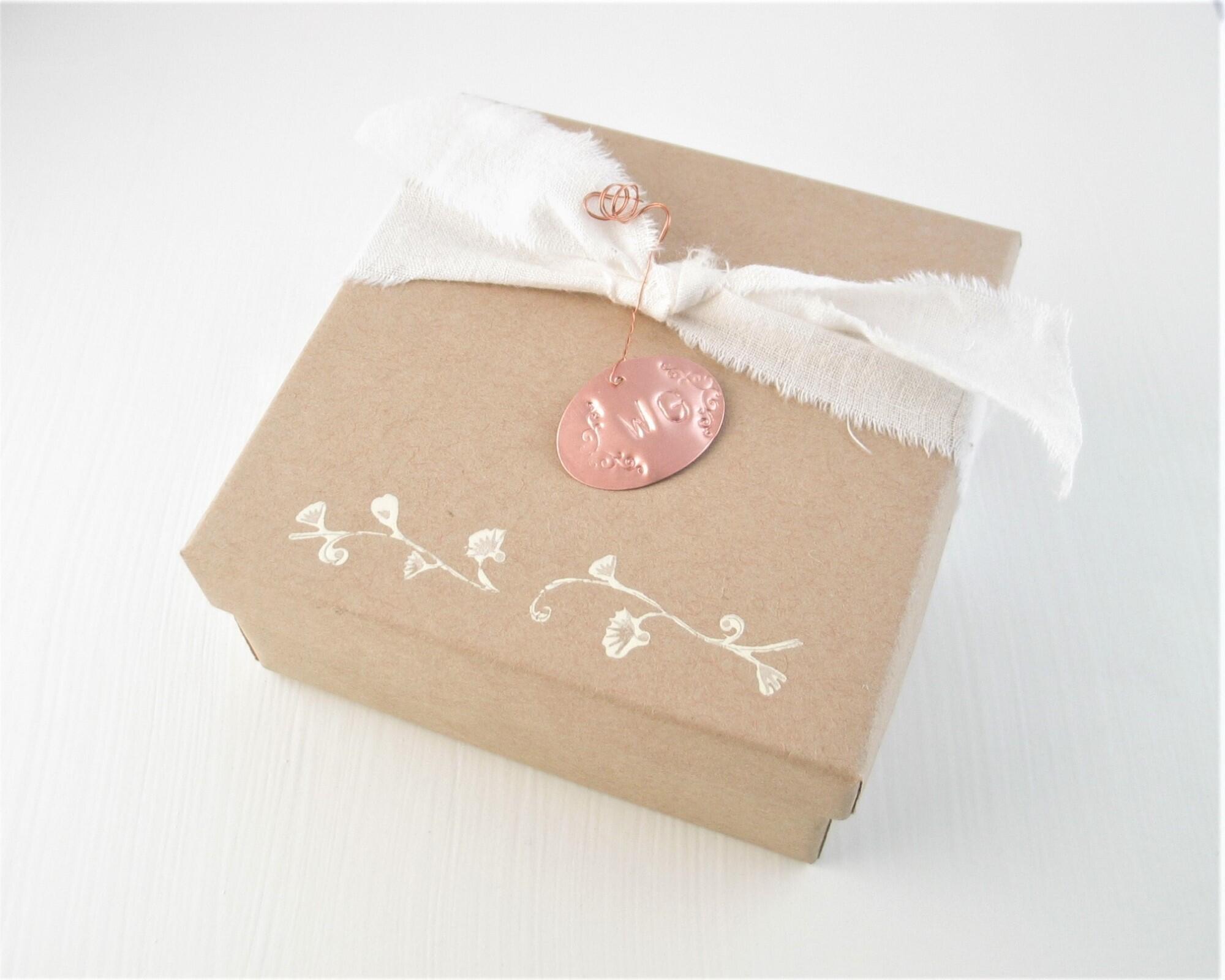 photo of gift box with muslin ribbon and copper charm with WG for wild gatherings