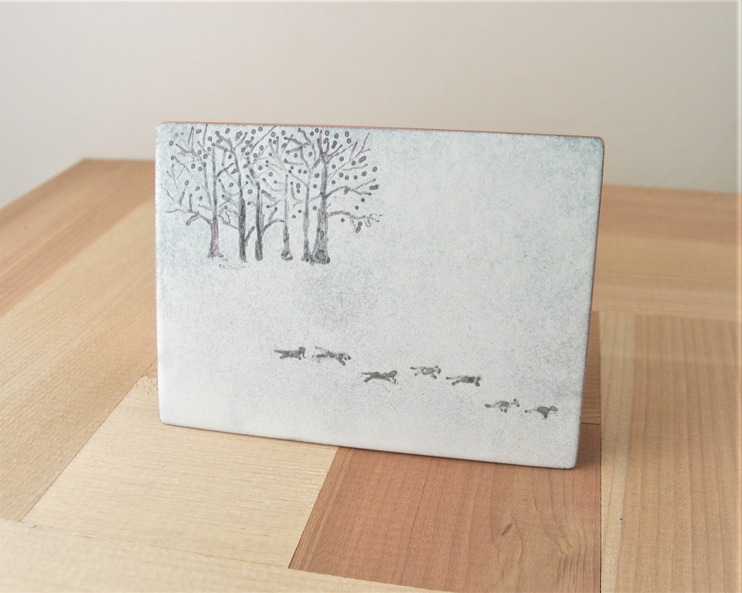 solid copper trinket box 3" x 2" with enameled lid with silhouettes of trees and running wolves