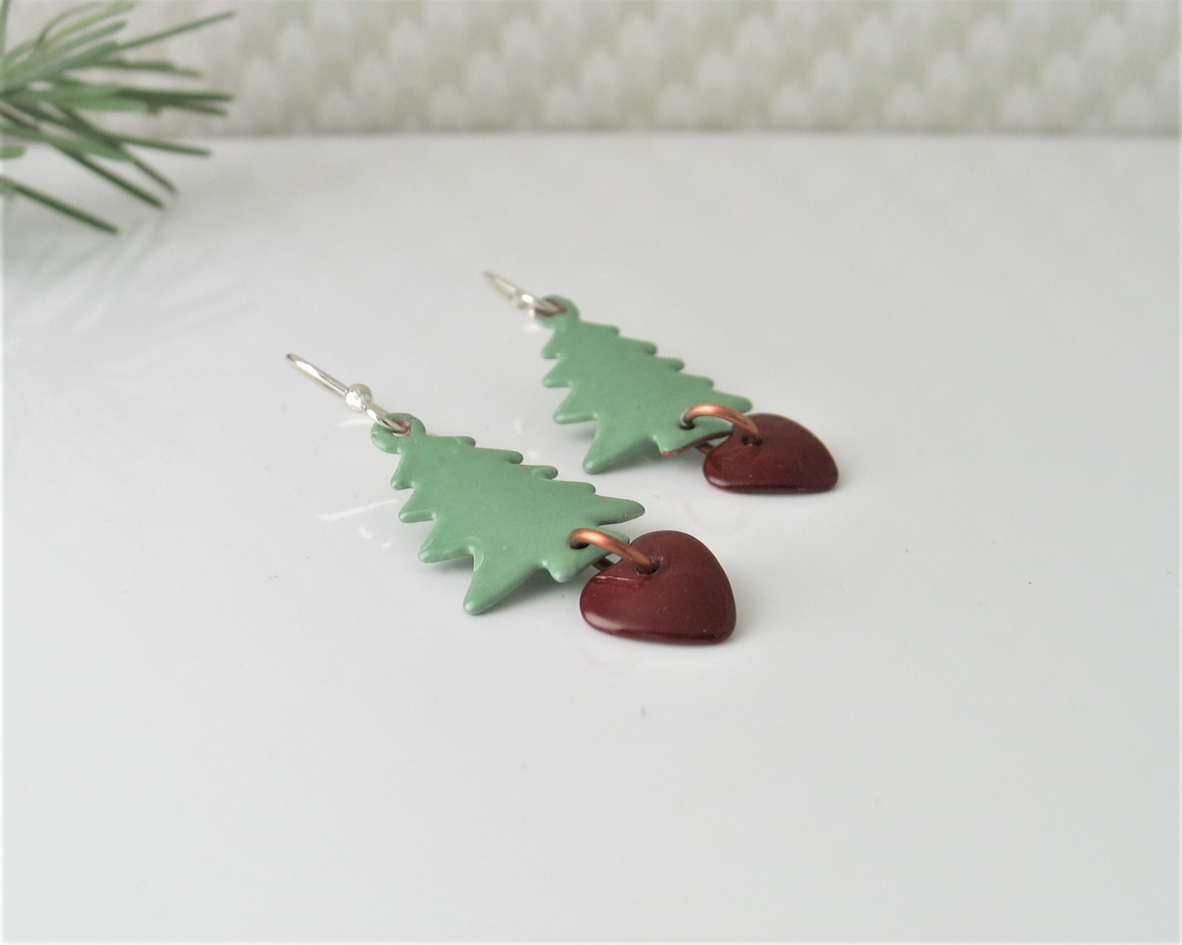 tree shaped earrings of light green with dangling dark red heart on argentium sterling earwires