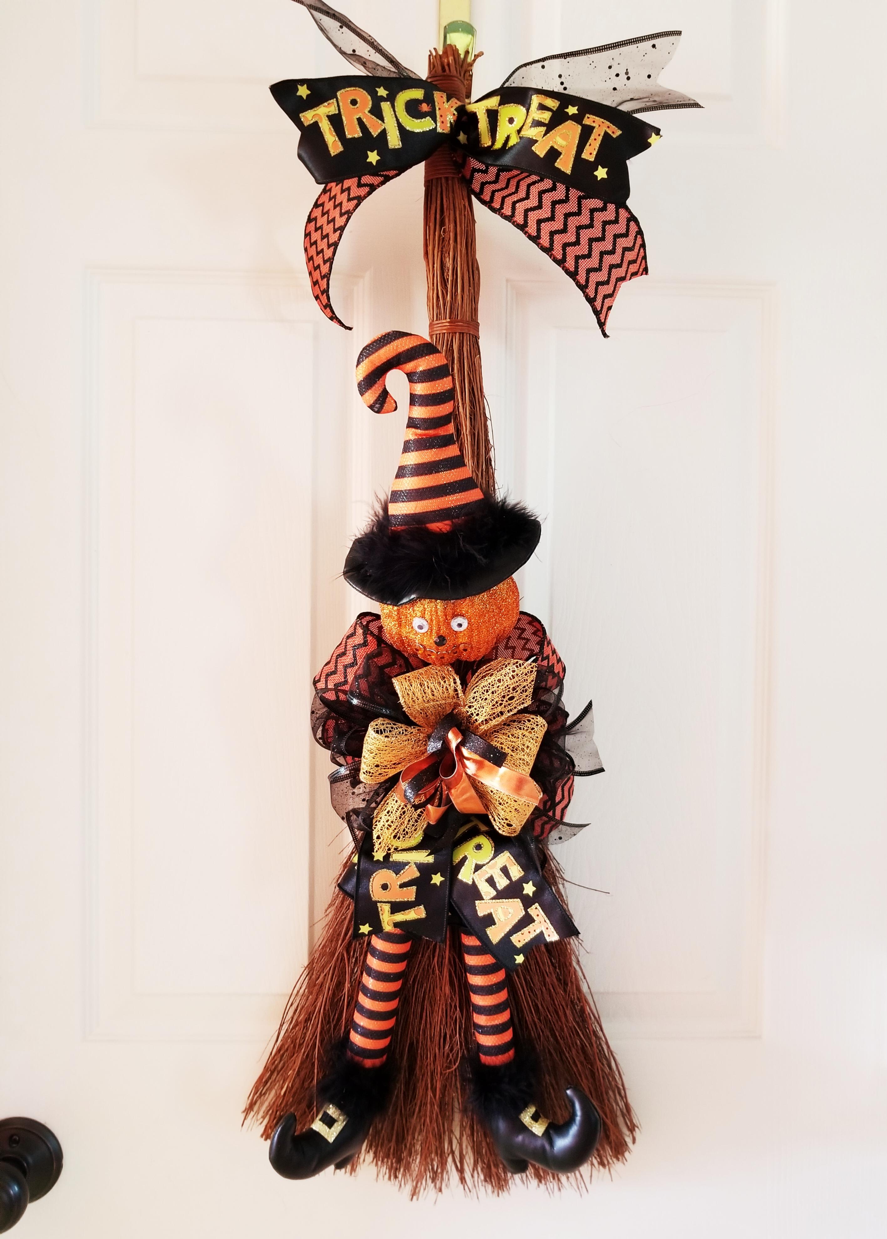 hanging green faced witch on broom halloween decoration