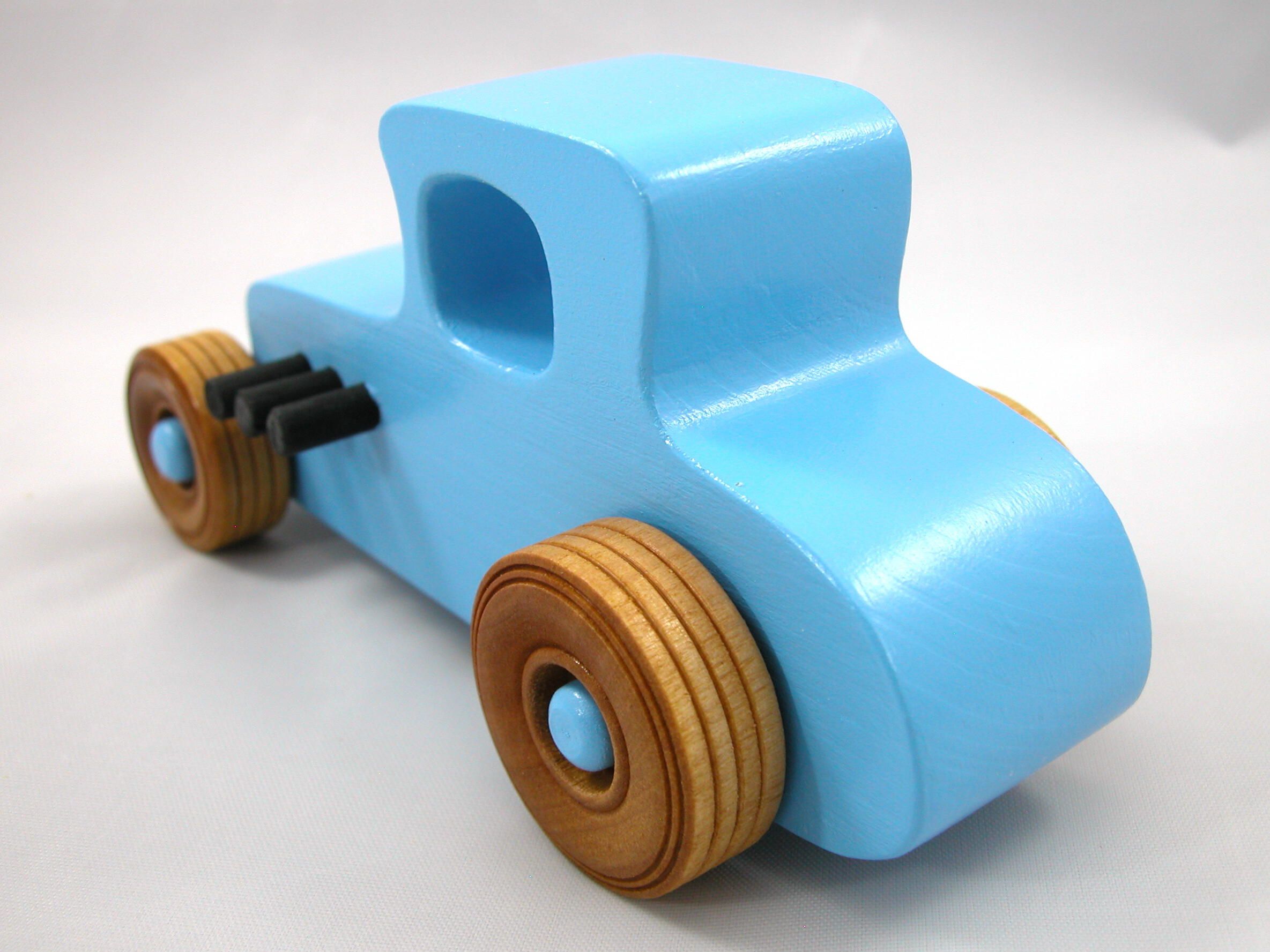 Handmade wooden toy car modeled after a '27 T-Coupe, finished with baby blue and black acrylic paint with nonmarring amber shellac wheels from my hot rod collection.