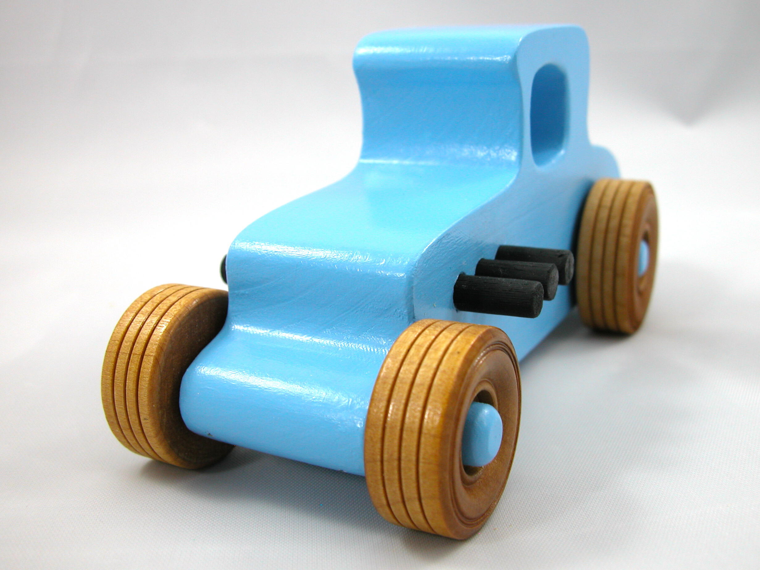 Handmade wooden toy car modeled after a '27 T-Coupe, finished with baby blue and black acrylic paint with nonmarring amber shellac wheels from my hot rod collection.