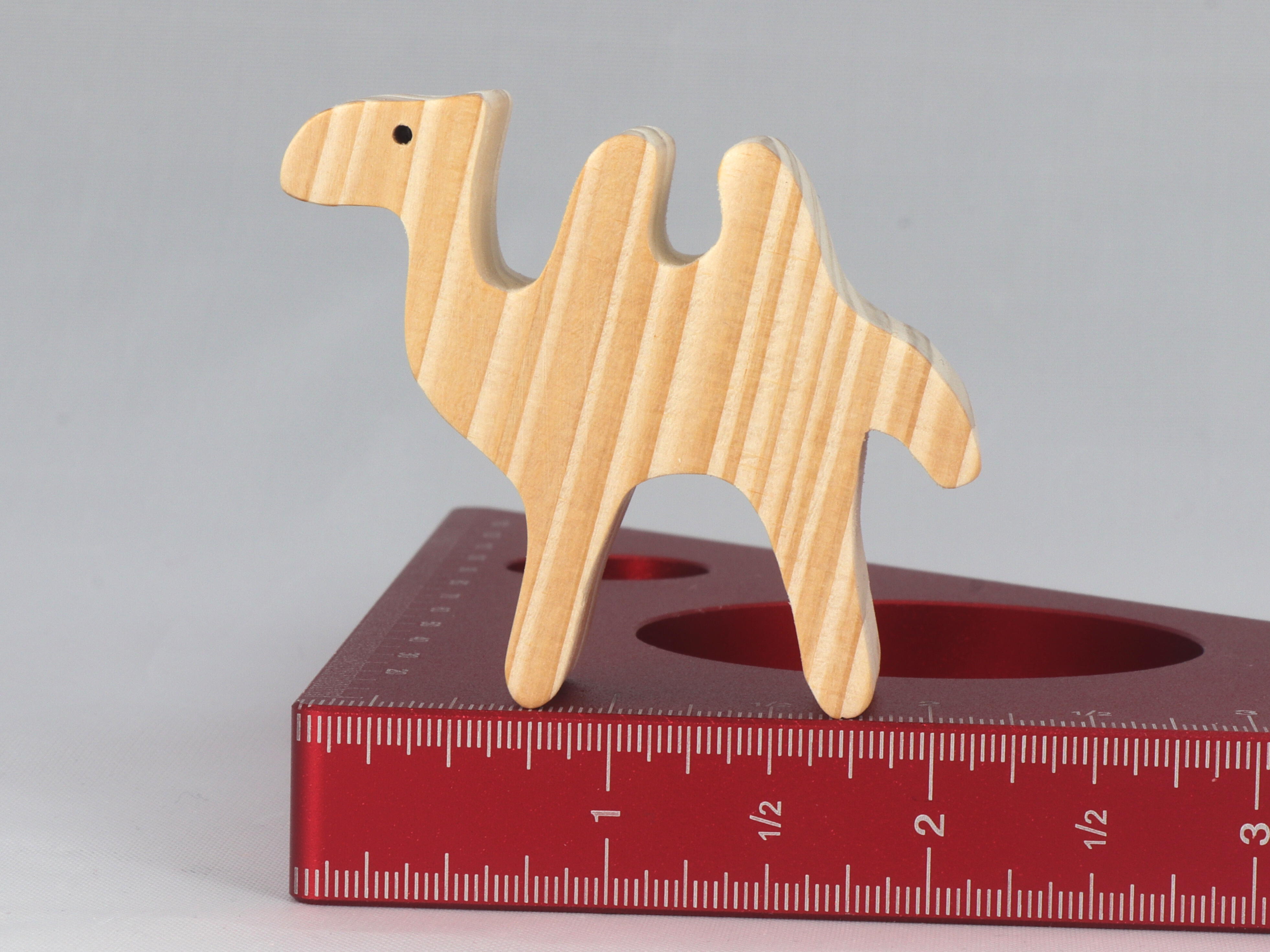 Handmade unfinished wood toy camel from the Itty Bitty Animal Collection sanded smooth and ready to paint. Ideal for kids' crafts or toys, this freestanding camel can be stacked with similar toys for a playful experience.