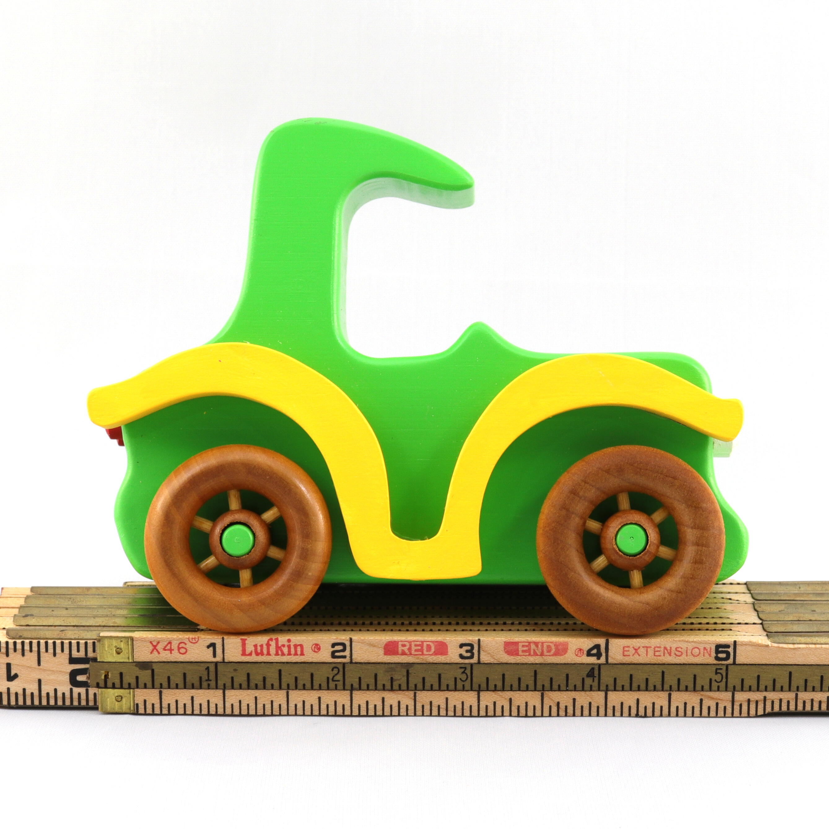 A handmade wooden toy car vintage style coupe painted nontoxic bright green and yellow with spoked wheels finished with nonmarring amber shellac, from my  Bad Bob's Custom Motors Collection.