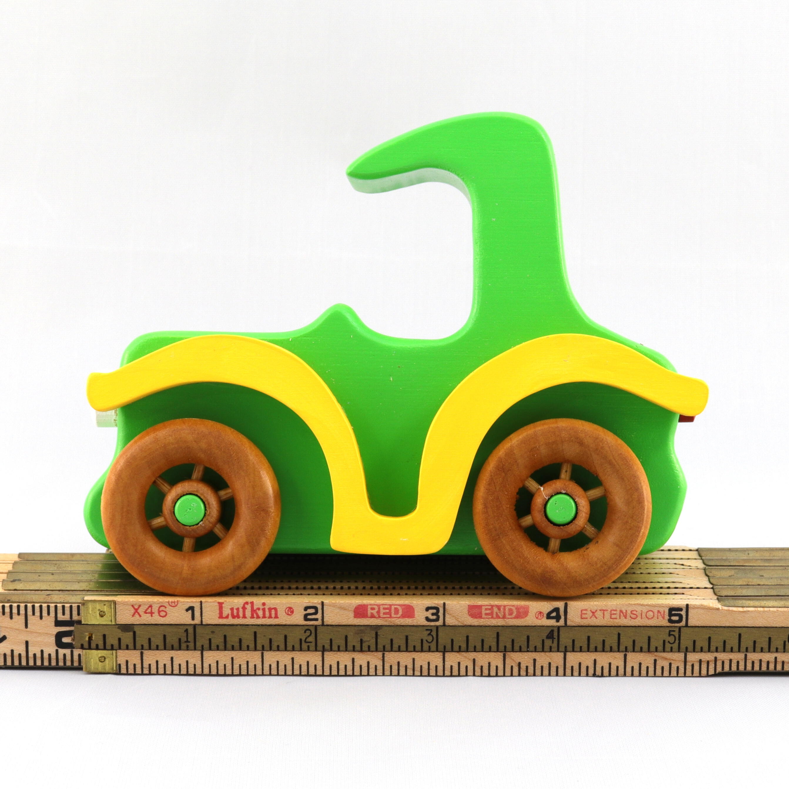 A handmade wooden toy car vintage style coupe painted nontoxic bright green and yellow with spoked wheels finished with nonmarring amber shellac, from my  Bad Bob's Custom Motors Collection.