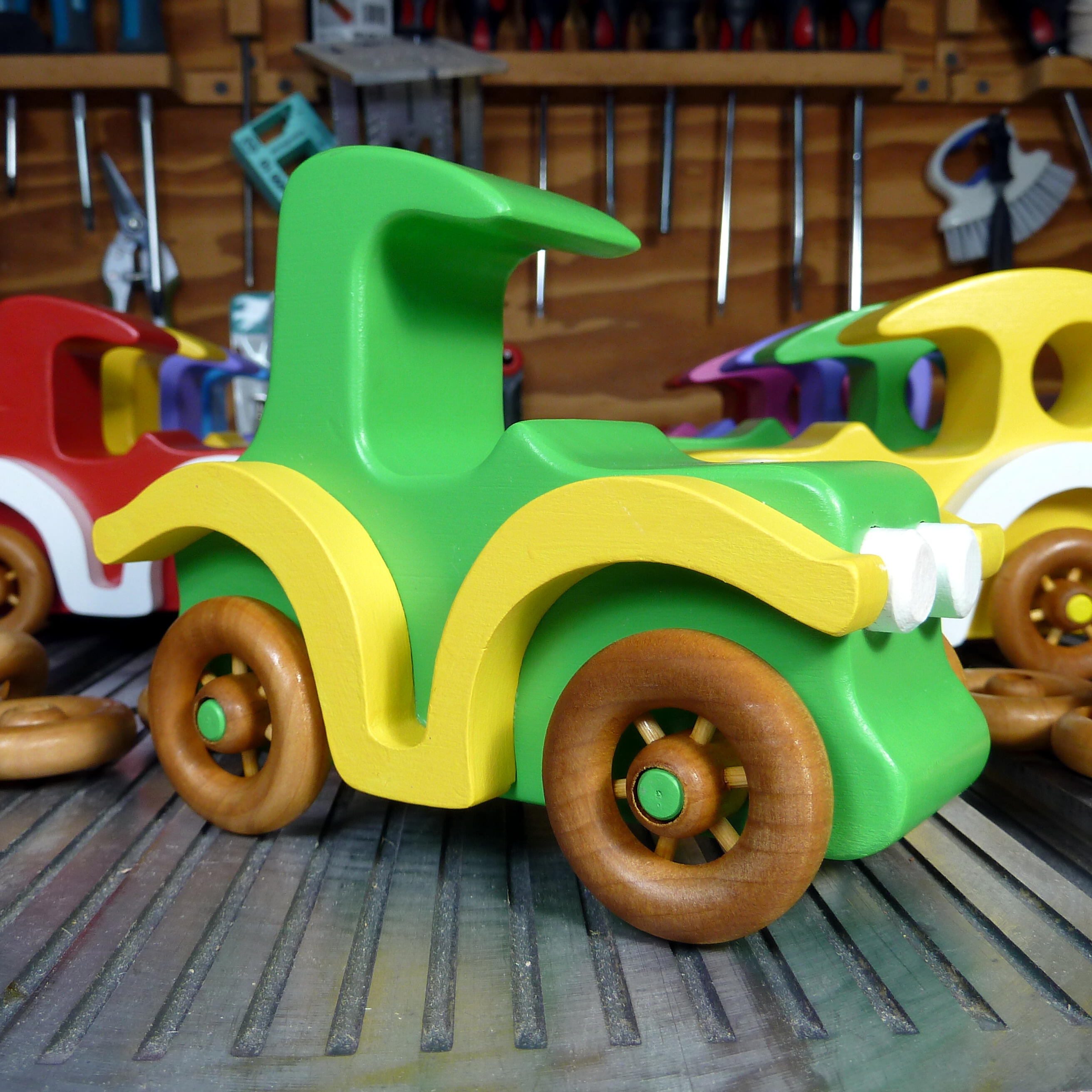 A handmade wooden toy car vintage style coupe painted nontoxic bright green and yellow with spoked wheels finished with nonmarring amber shellac, from my  Bad Bob's Custom Motors Collection.