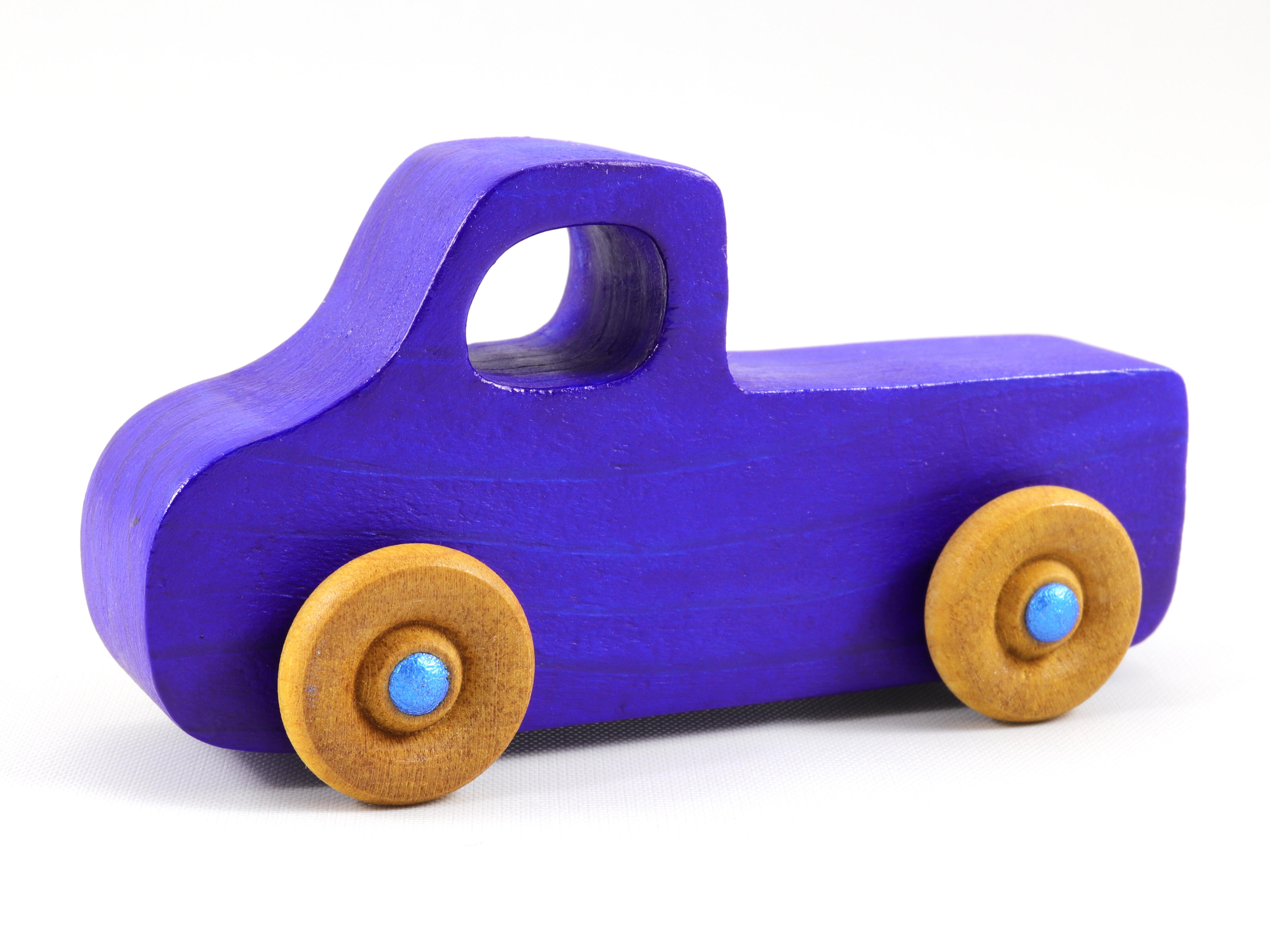 A handmade wooden toy pickup truck painted with bright blue and metallic sapphire blue paint. The wheels are finished with non-marring amber shellac. This toy is part of my Play Pal Collection.