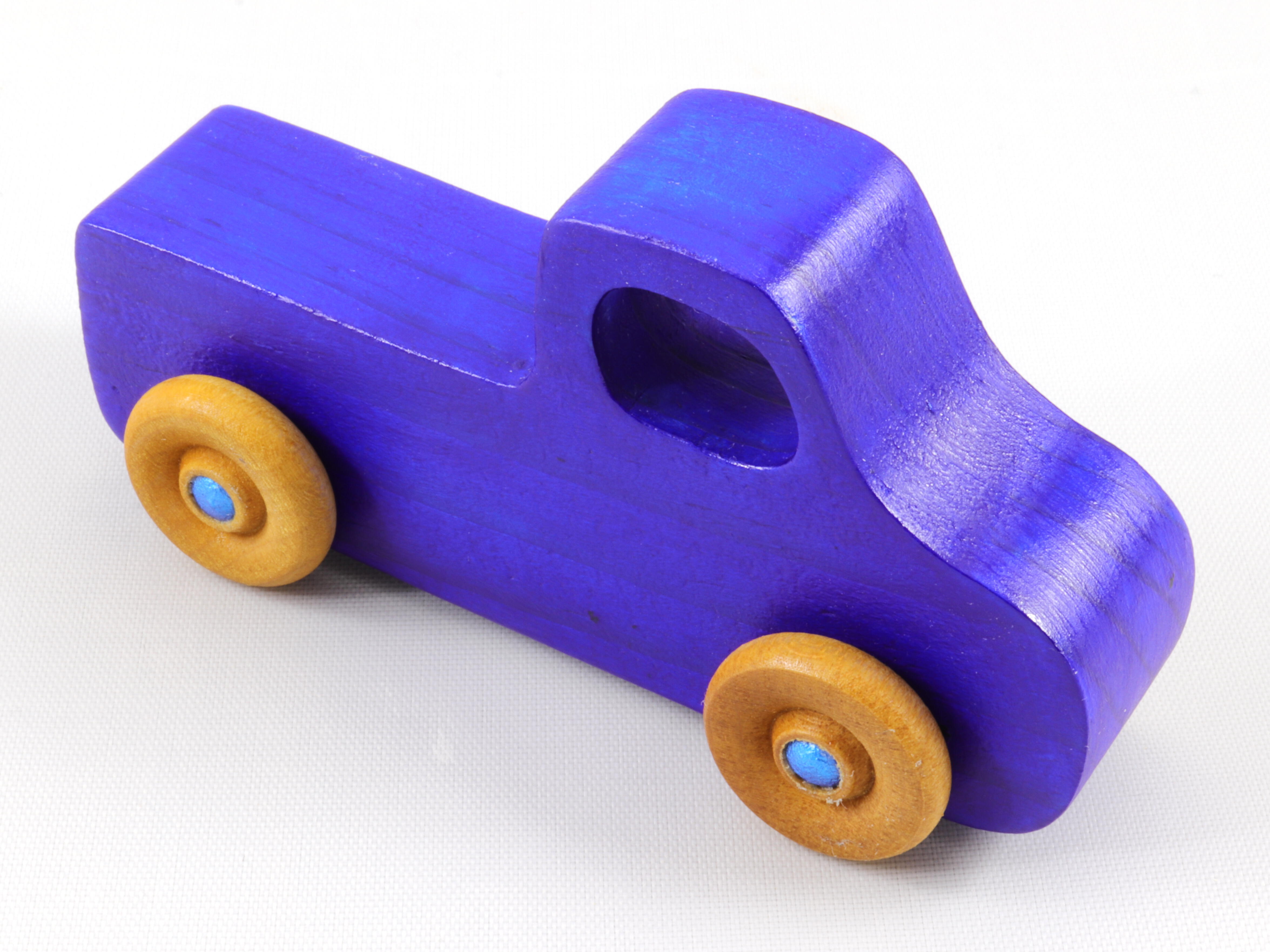 A handmade wooden toy pickup truck painted with bright blue and metallic sapphire blue paint. The wheels are finished with non-marring amber shellac. This toy is part of my Play Pal Collection.