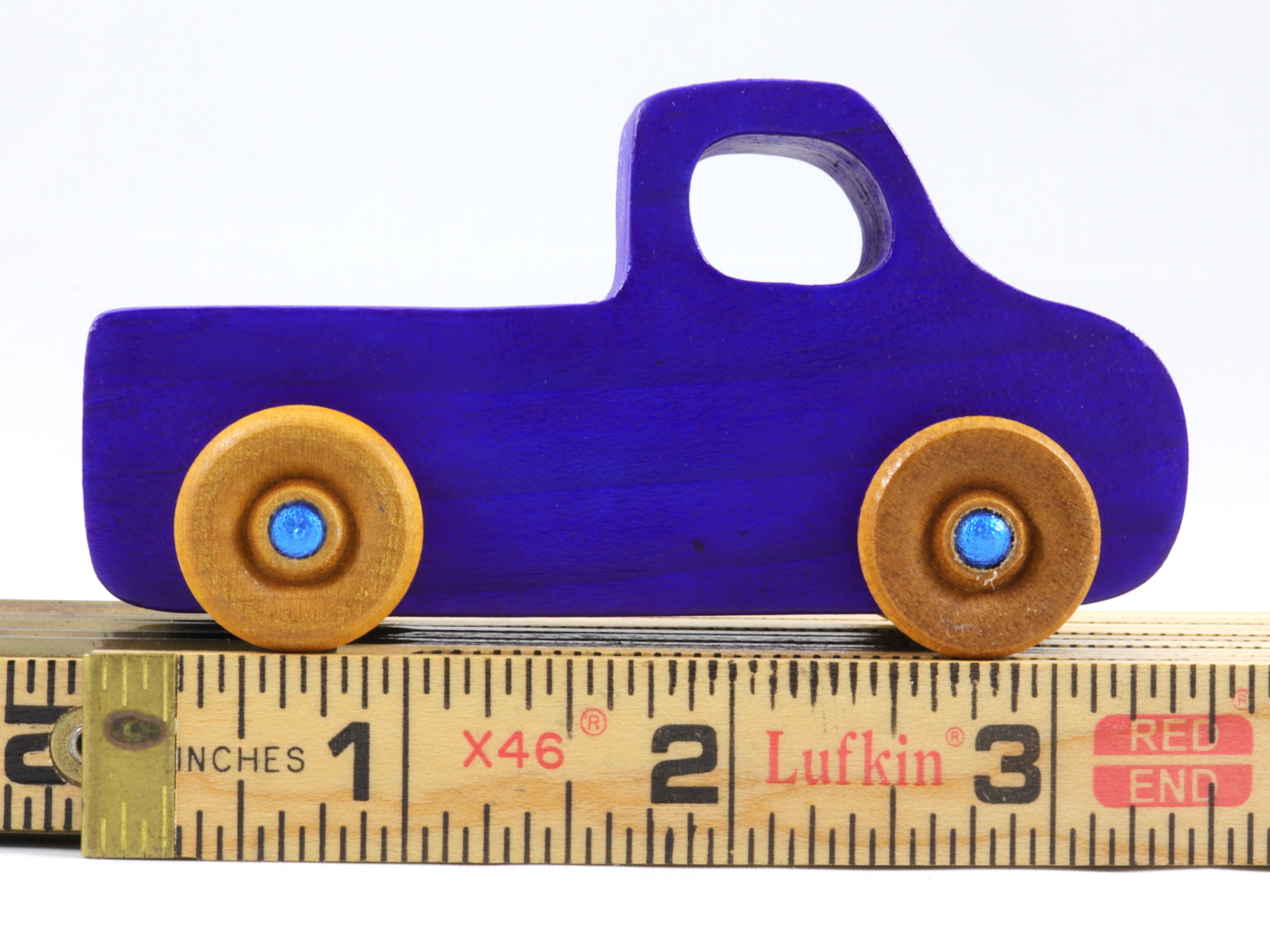 A handmade wooden toy pickup truck painted with bright blue and metallic sapphire blue paint. The wheels are finished with non-marring amber shellac. This toy is part of my Play Pal Collection.