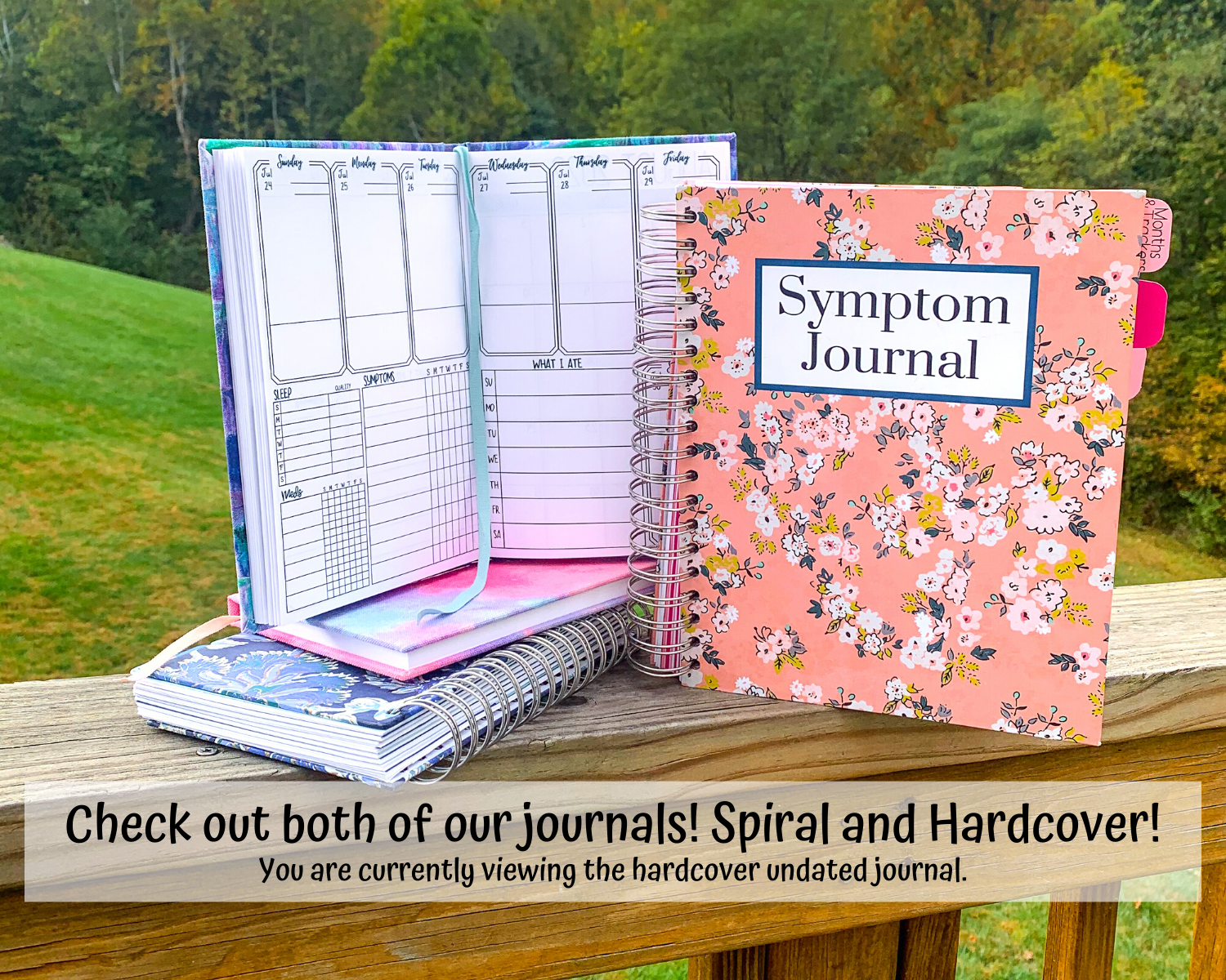 One of the journals shown is sitting on top of another hardcover book in pink, and a blue spiral bound book. A large pink spiral bound book is shown closed to it's right with a label that says Symptom Journal. A note says check out both of our journals Spiral and Hardcover. You are currently viewing the hardcover style.