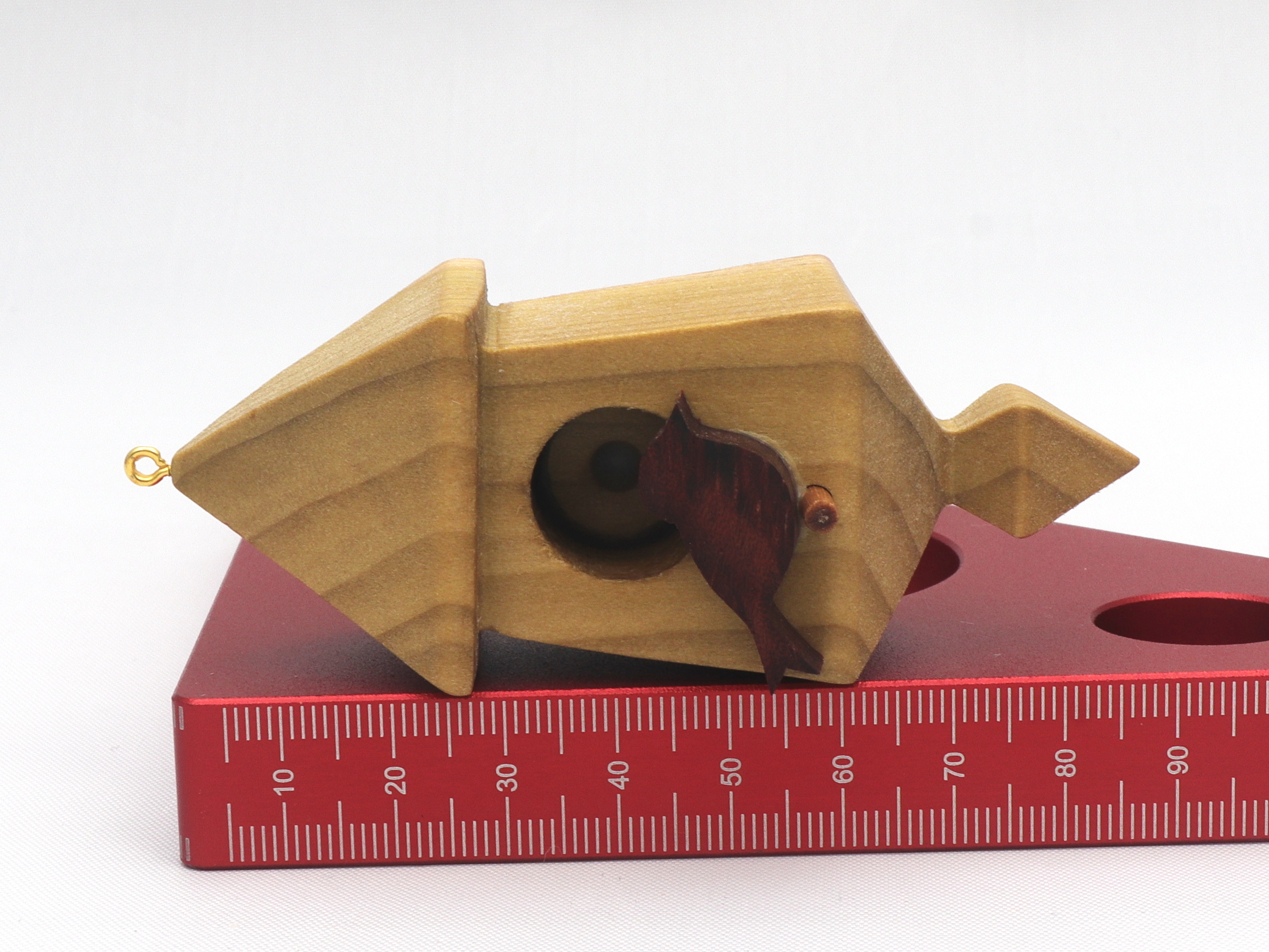 Handmade miniature birdhouse ornament crafted from select hardwoods, featuring a meticulous finish with a beeswax and oil blend—a collectible and charming decorative piece.