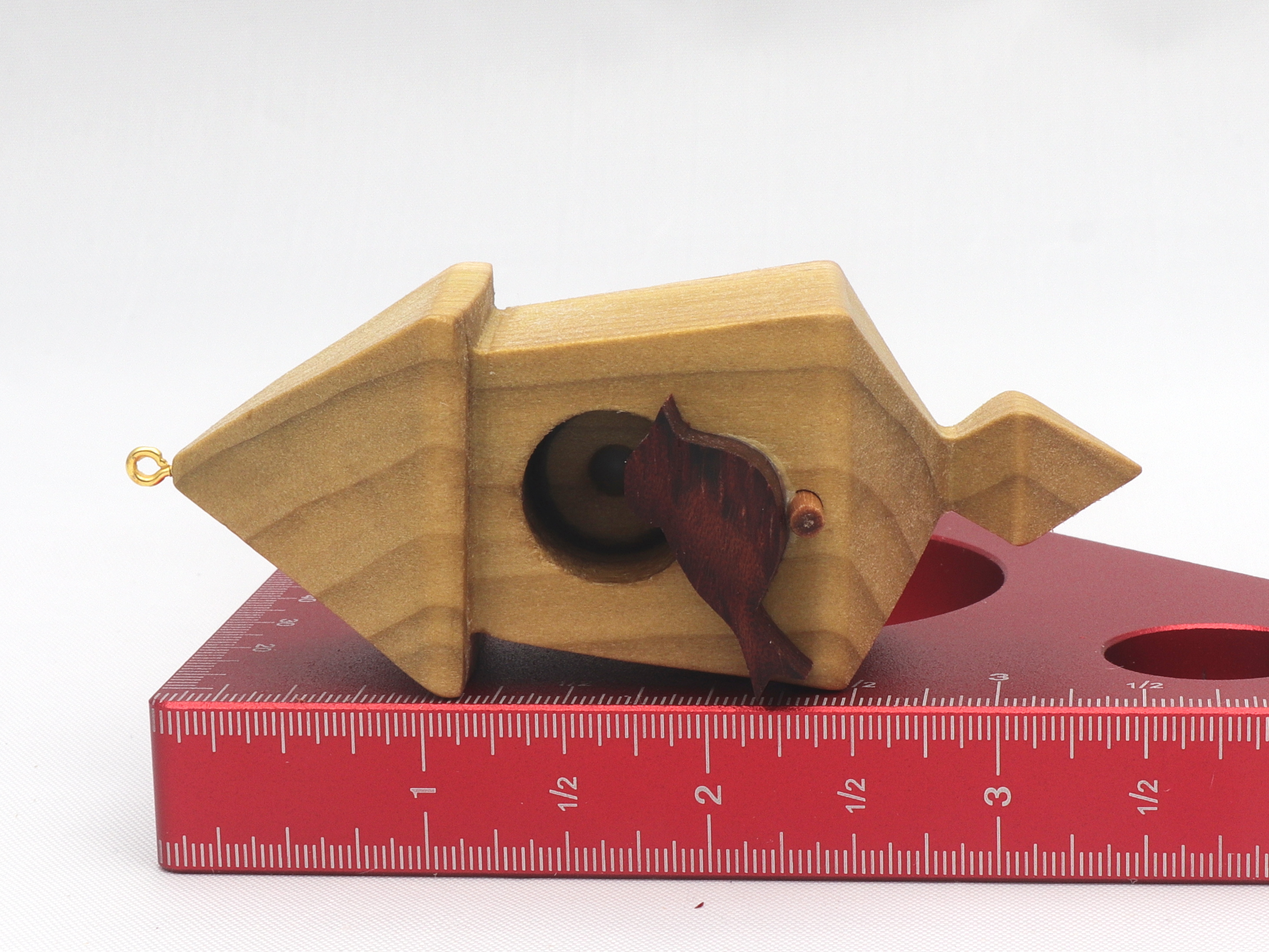 Handmade miniature birdhouse ornament crafted from select hardwoods, featuring a meticulous finish with a beeswax and oil blend—a collectible and charming decorative piece.