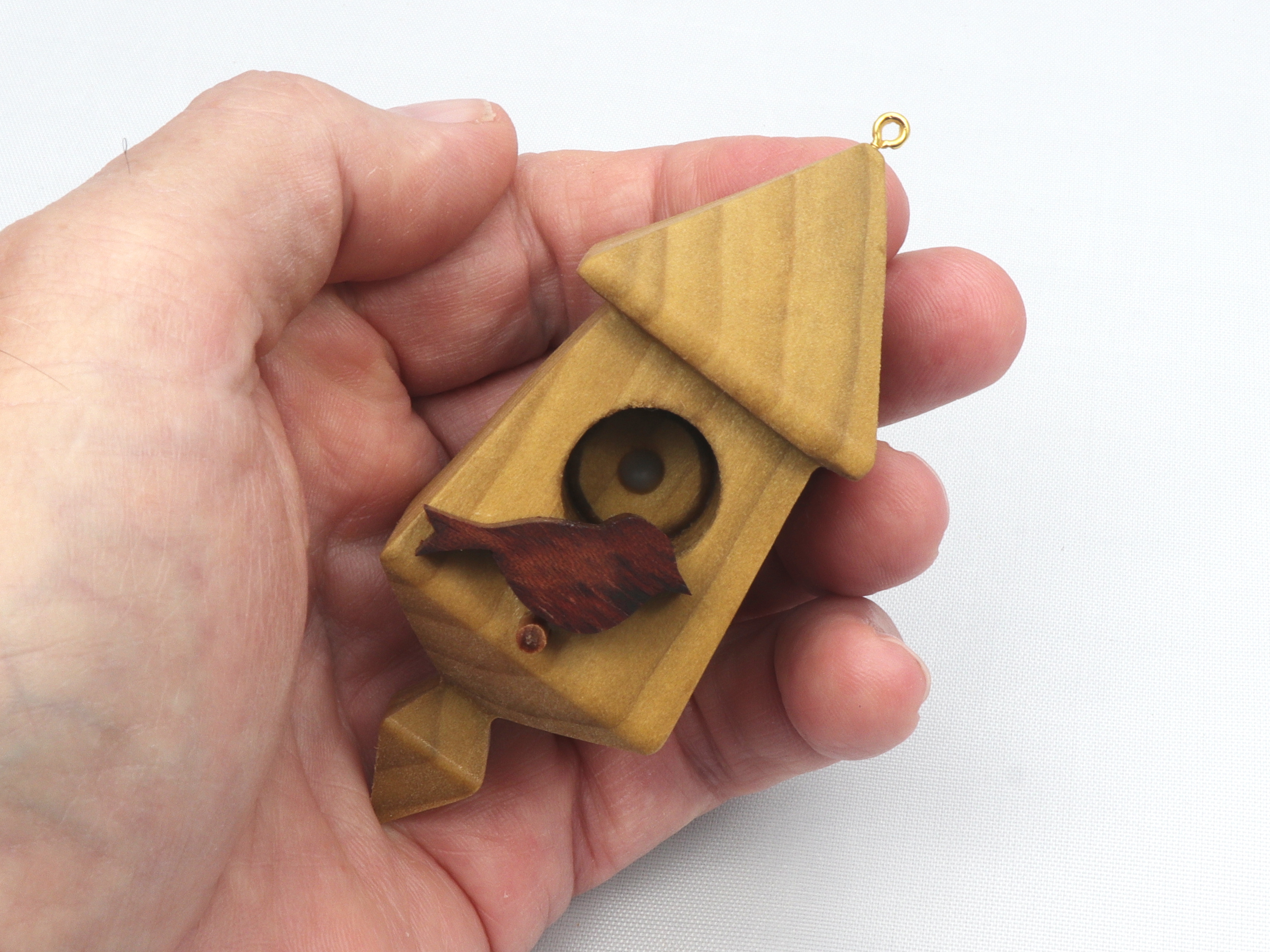 Handmade miniature birdhouse ornament crafted from select hardwoods, featuring a meticulous finish with a beeswax and oil blend—a collectible and charming decorative piece.