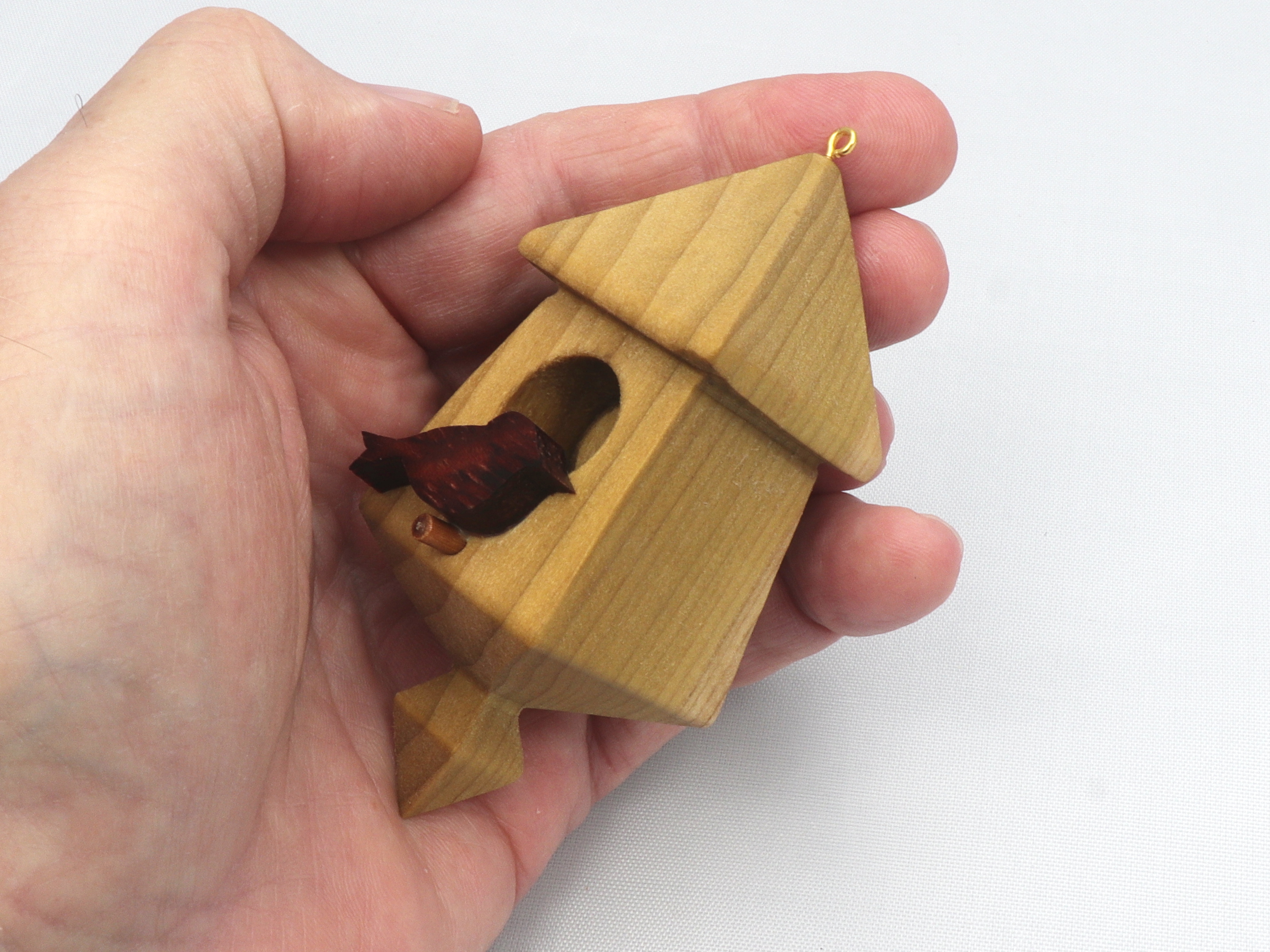 Handmade miniature birdhouse ornament crafted from select hardwoods, featuring a meticulous finish with a beeswax and oil blend—a collectible and charming decorative piece.