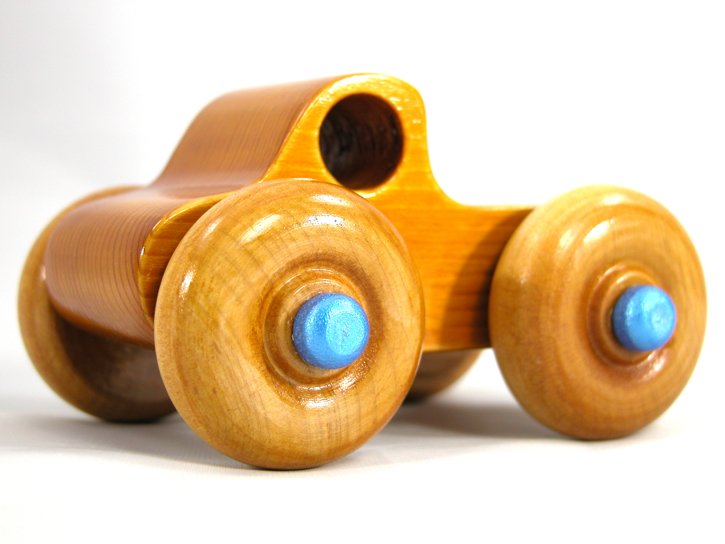 Handmade Wooden Toy Truck With Round Windows Finished with Glossy Amber Shellac and Metallic Sapphire Blue Acrylic Paint trim. Excellent, durable push toy for toddlers with chunky wheels that roll well on any surface.