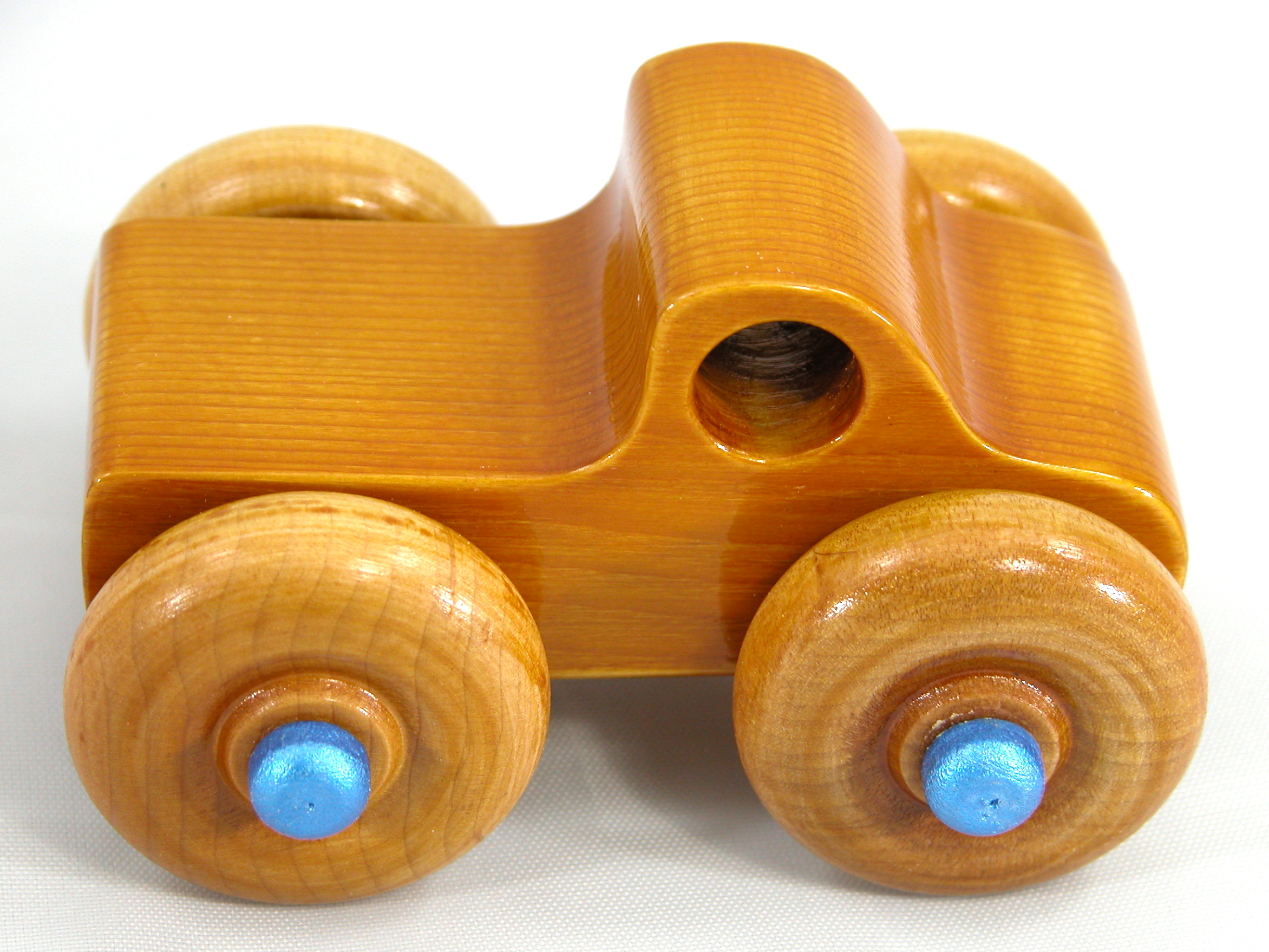 Handmade Wooden Toy Truck With Round Windows Finished with Glossy Amber Shellac and Metallic Sapphire Blue Acrylic Paint trim. Excellent, durable push toy for toddlers with chunky wheels that roll well on any surface.
