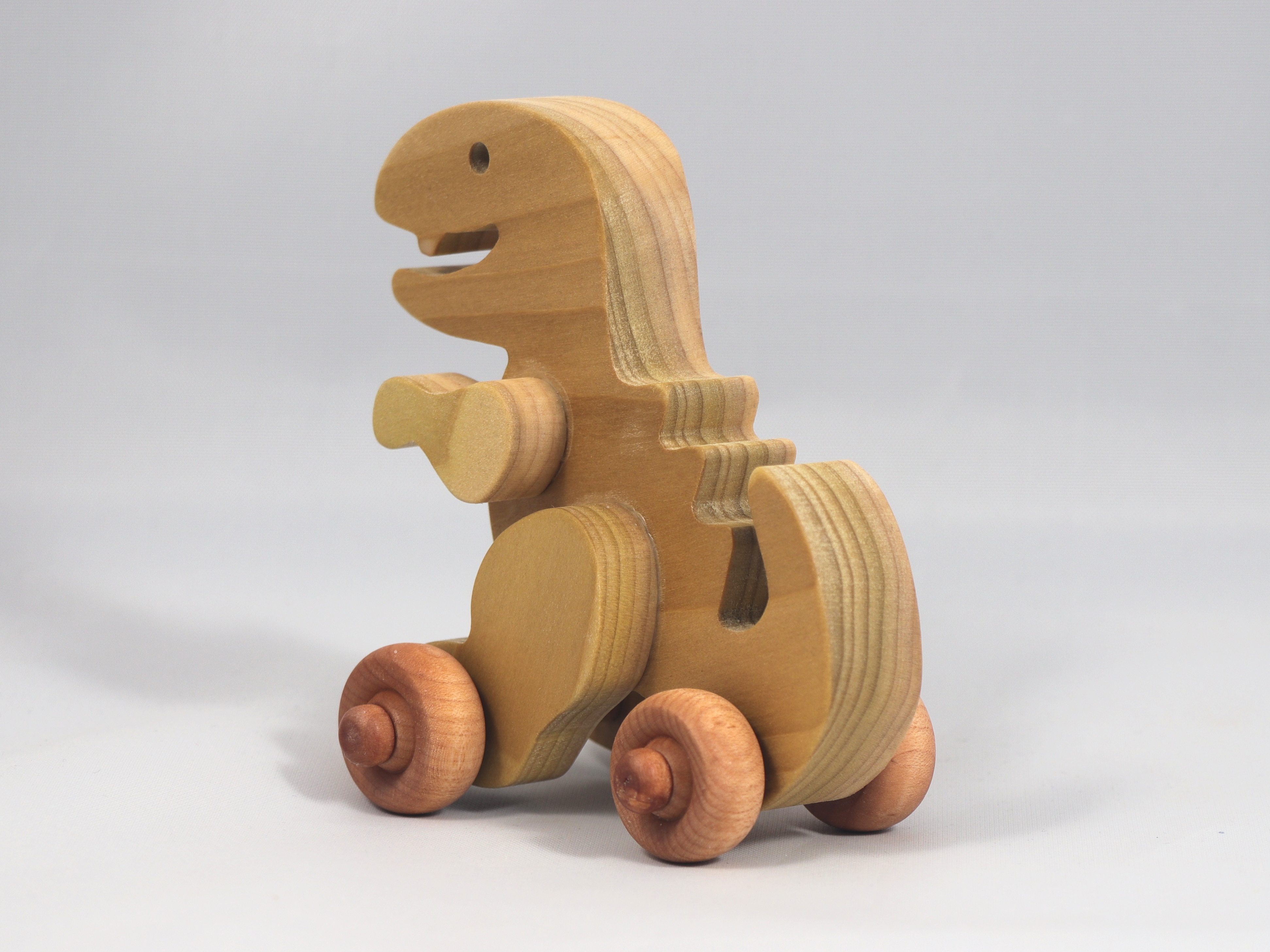 Handmade wooden push toy Tyrannosaurus Rex (T-Rex) dinosaur made from select grade hardwoods and finished with a non-toxic coating.