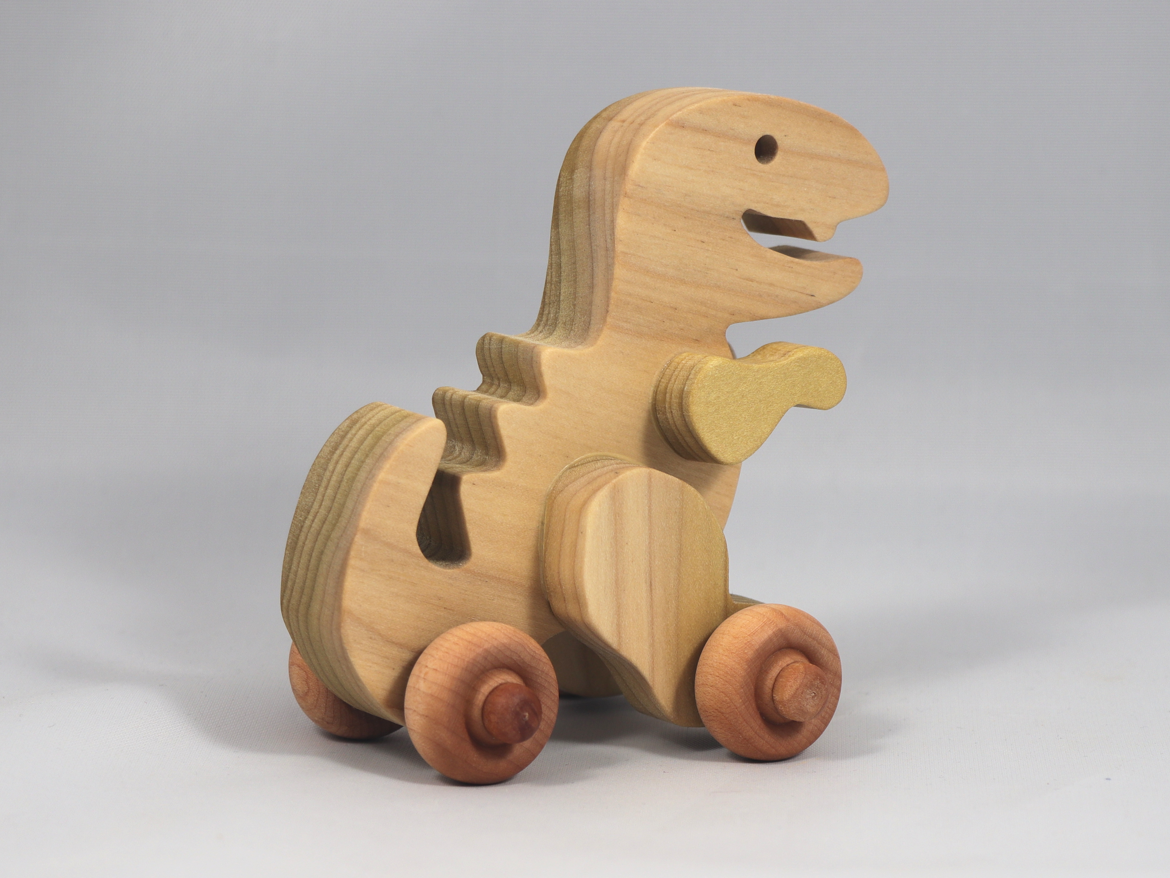Handmade wooden push toy Tyrannosaurus Rex (T-Rex) dinosaur made from select grade hardwoods and finished with a non-toxic coating.