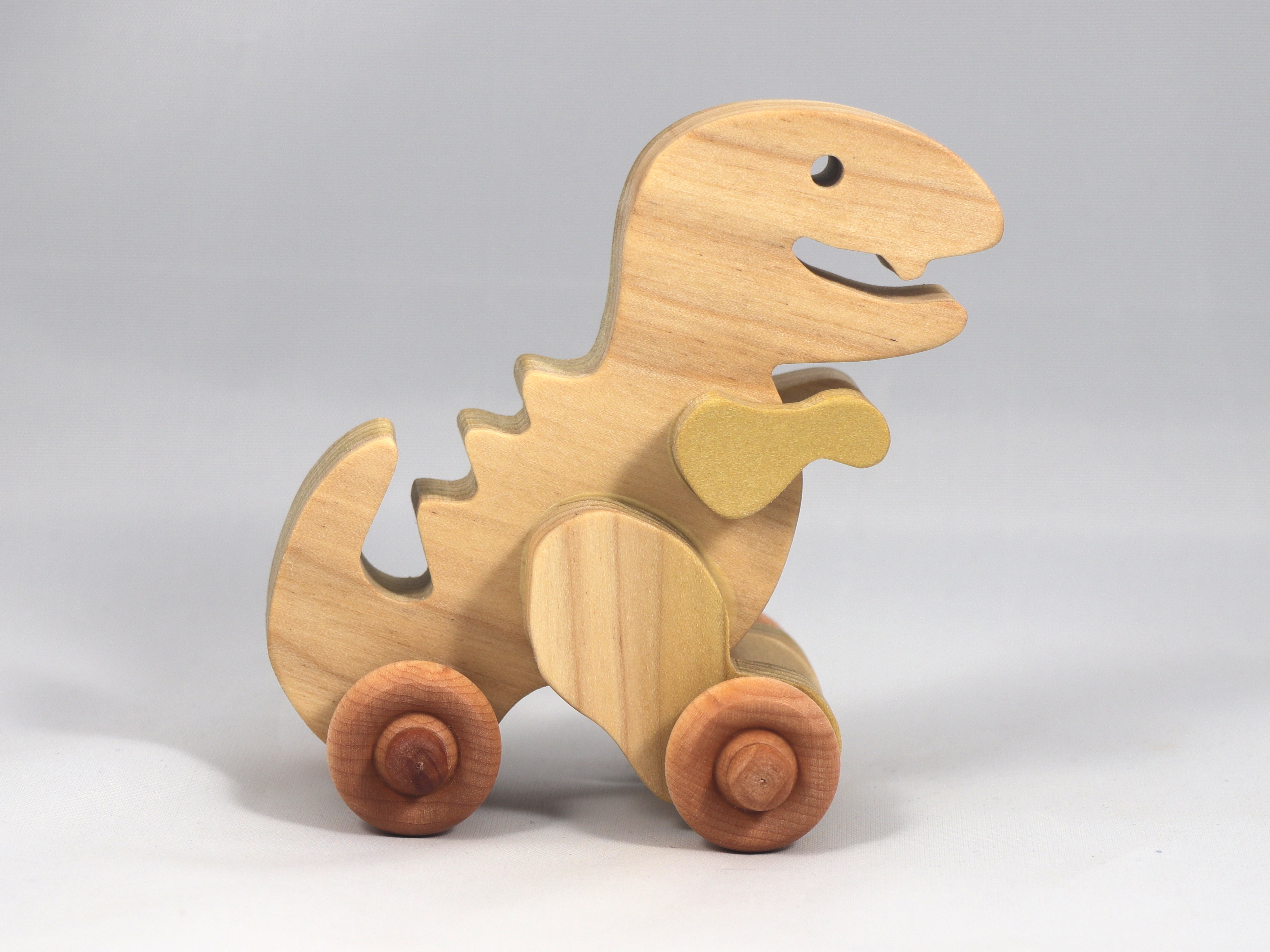 Handmade wooden push toy Tyrannosaurus Rex (T-Rex) dinosaur made from select grade hardwoods and finished with a non-toxic coating.