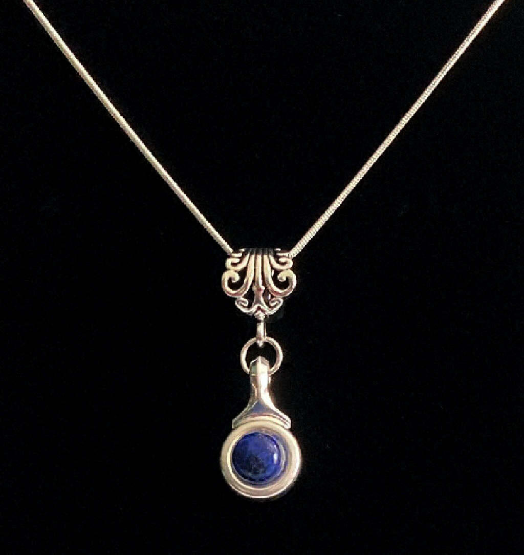 Beautiful Lapis  stone is viewed on a flute trill key.  A fleur de lis bail on a  16" silver plated snake chain.