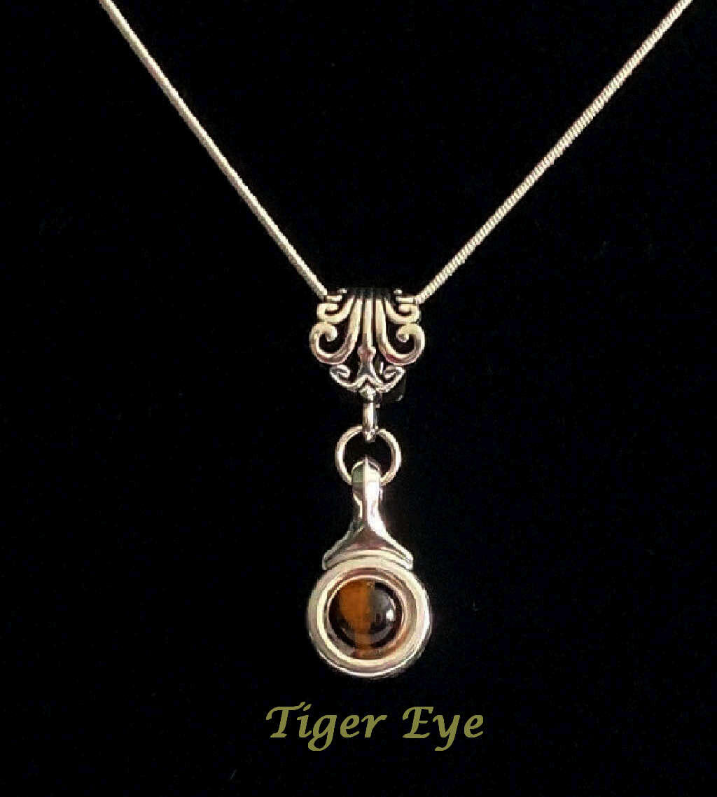 Beautiful Tiger Eye stone is viewed on a flute trill key.  A fleur de lis bail on a  16" silver plated snake chain.