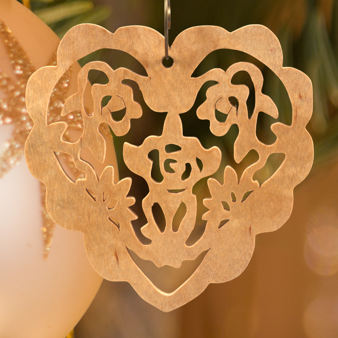 A handmade wooden Victorian-style fretwork floral heart Christmas tree ornament, featuring intricate cutout floral patterns in a heart shape, with a warm natural wood finish.