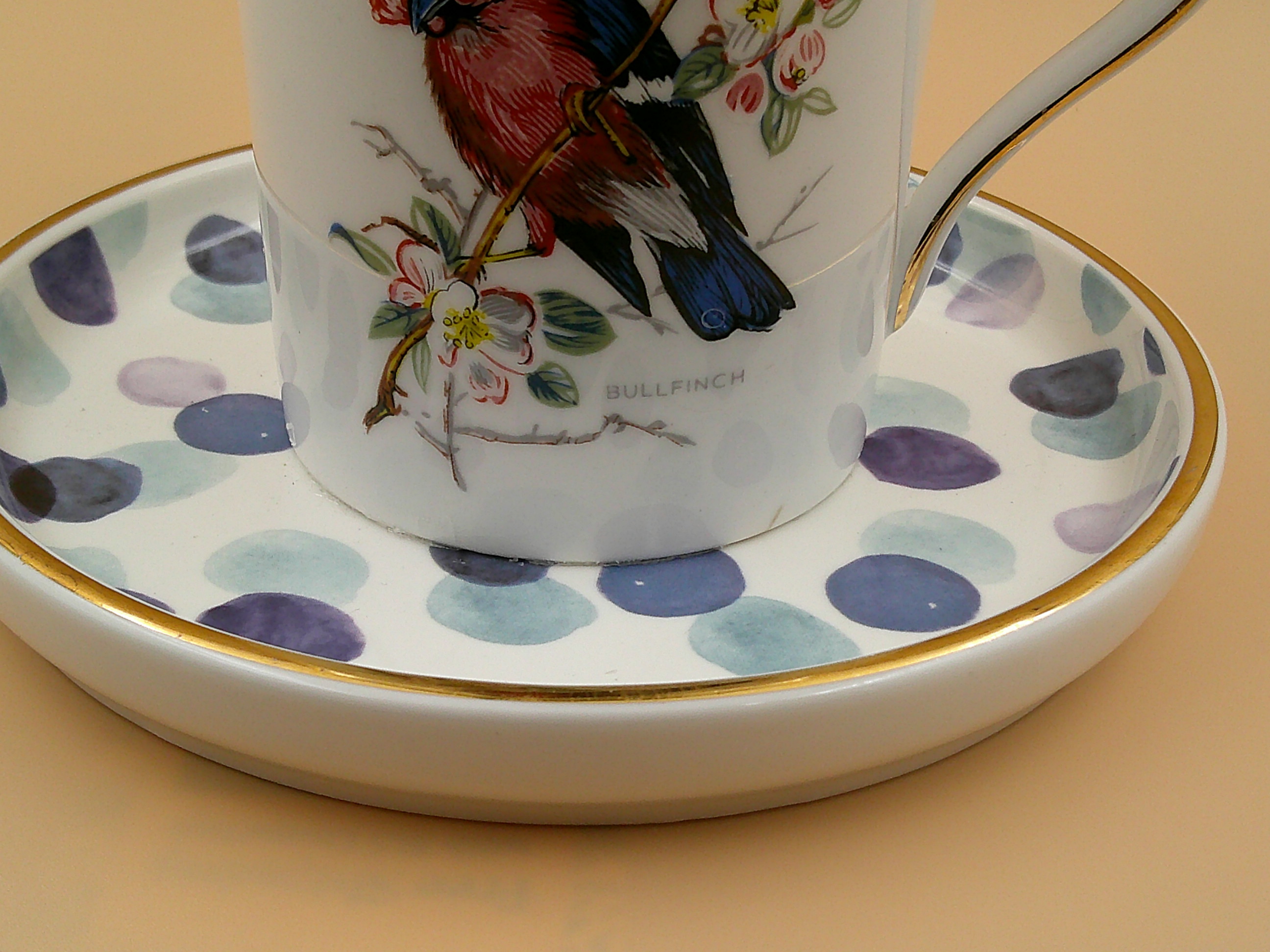 This is a closeup of the saucer and part of the bird on the teacup.  A variety of blues and each has gold trim. This is a closeup of the saucer and part of the bird on the teacup.  A variety of blues and each has gold trim.