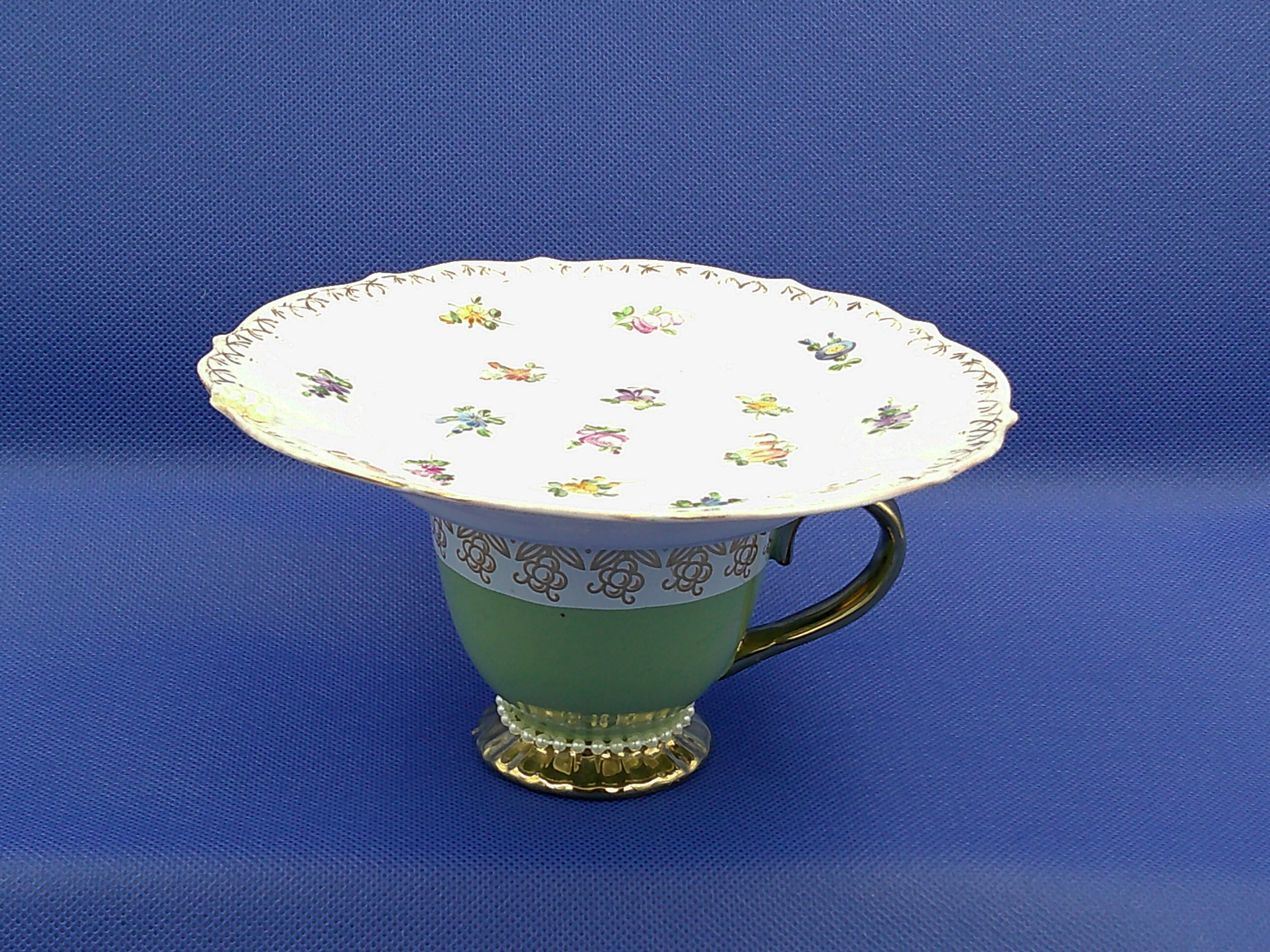 This gives an idea of the size, regular cup and saucer size. It's petite, 6.5 inches wide by 3.5 inches high. This gives an idea of the size, regular cup and saucer size. It's petite, 6.5 inches wide by 3.5 inches high.