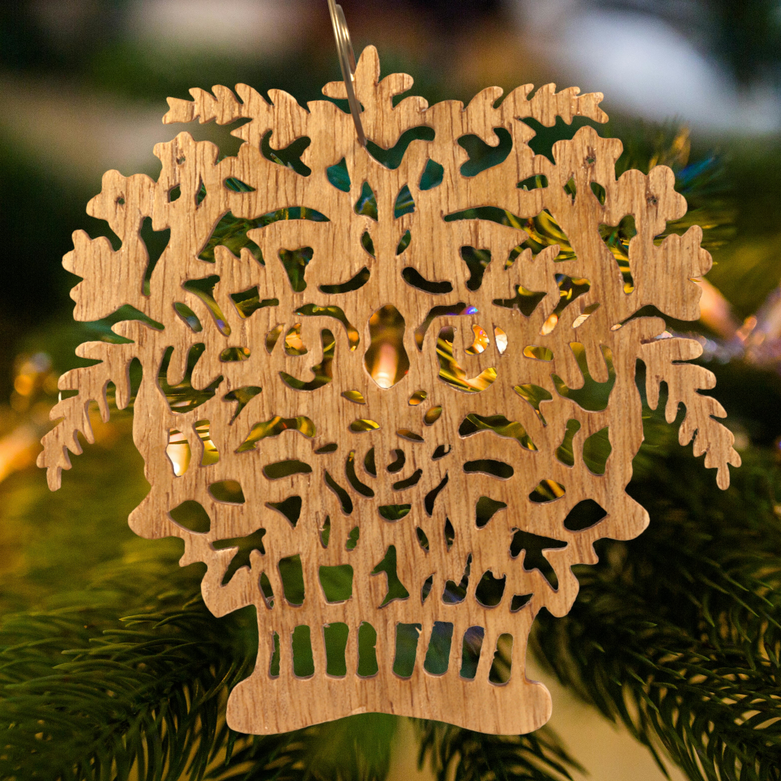 A handcrafted Victorian-style wooden Christmas tree ornament shaped like a basket filled with intricate floral designs, featuring detailed leaves and blossoms, with a small hook at the top for hanging.