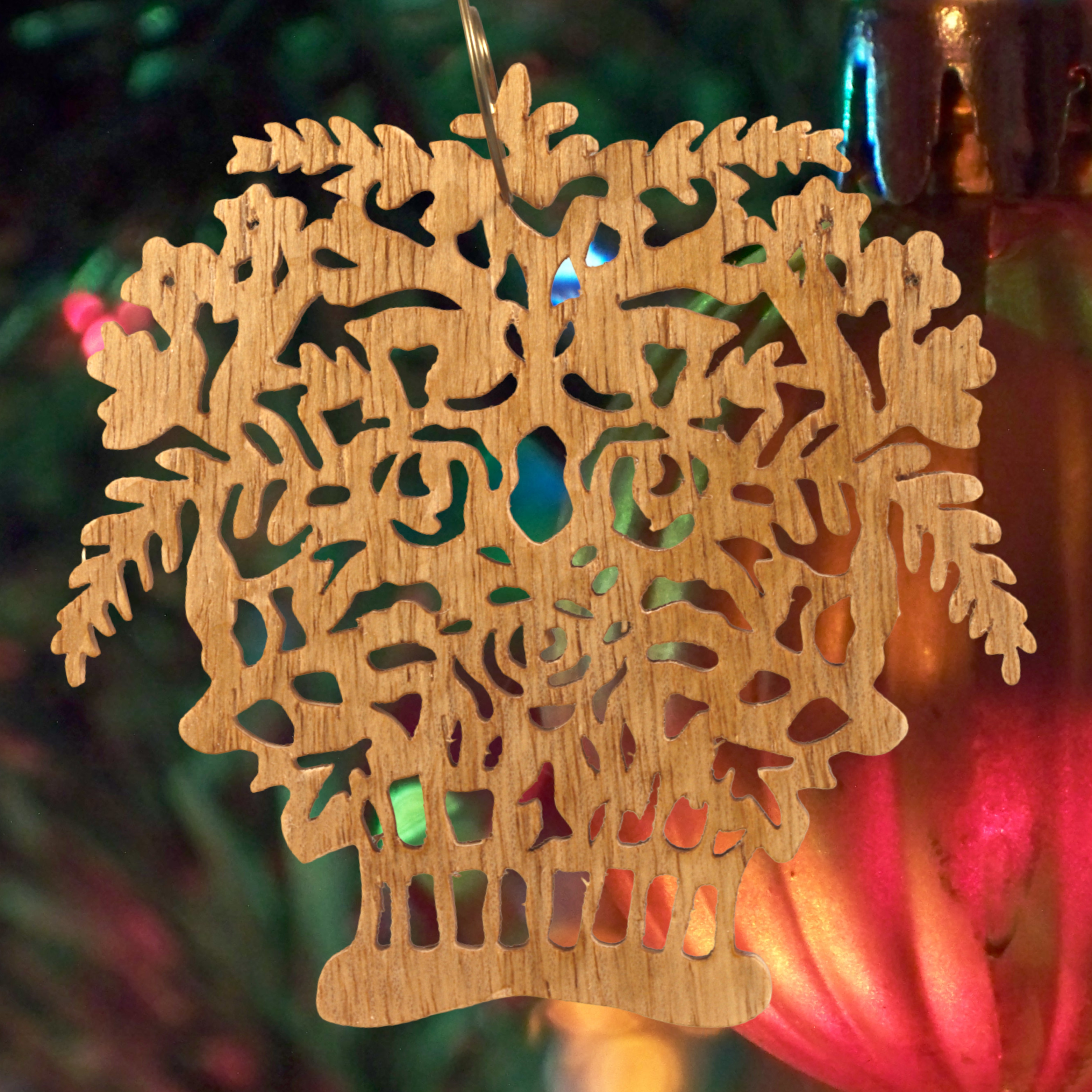 A handcrafted Victorian-style wooden Christmas tree ornament shaped like a basket filled with intricate floral designs, featuring detailed leaves and blossoms, with a small hook at the top for hanging.