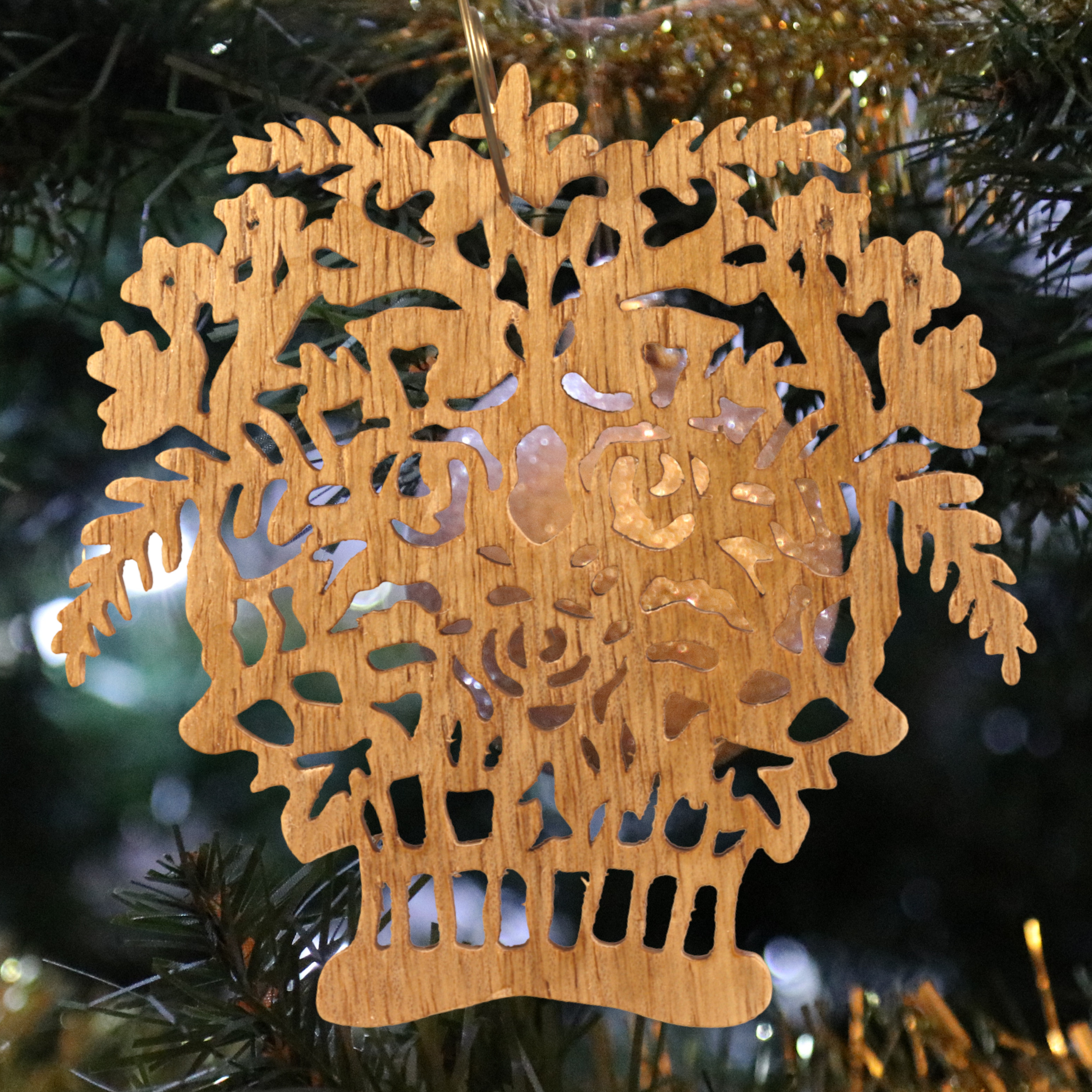 A handcrafted Victorian-style wooden Christmas tree ornament shaped like a basket filled with intricate floral designs, featuring detailed leaves and blossoms, with a small hook at the top for hanging.