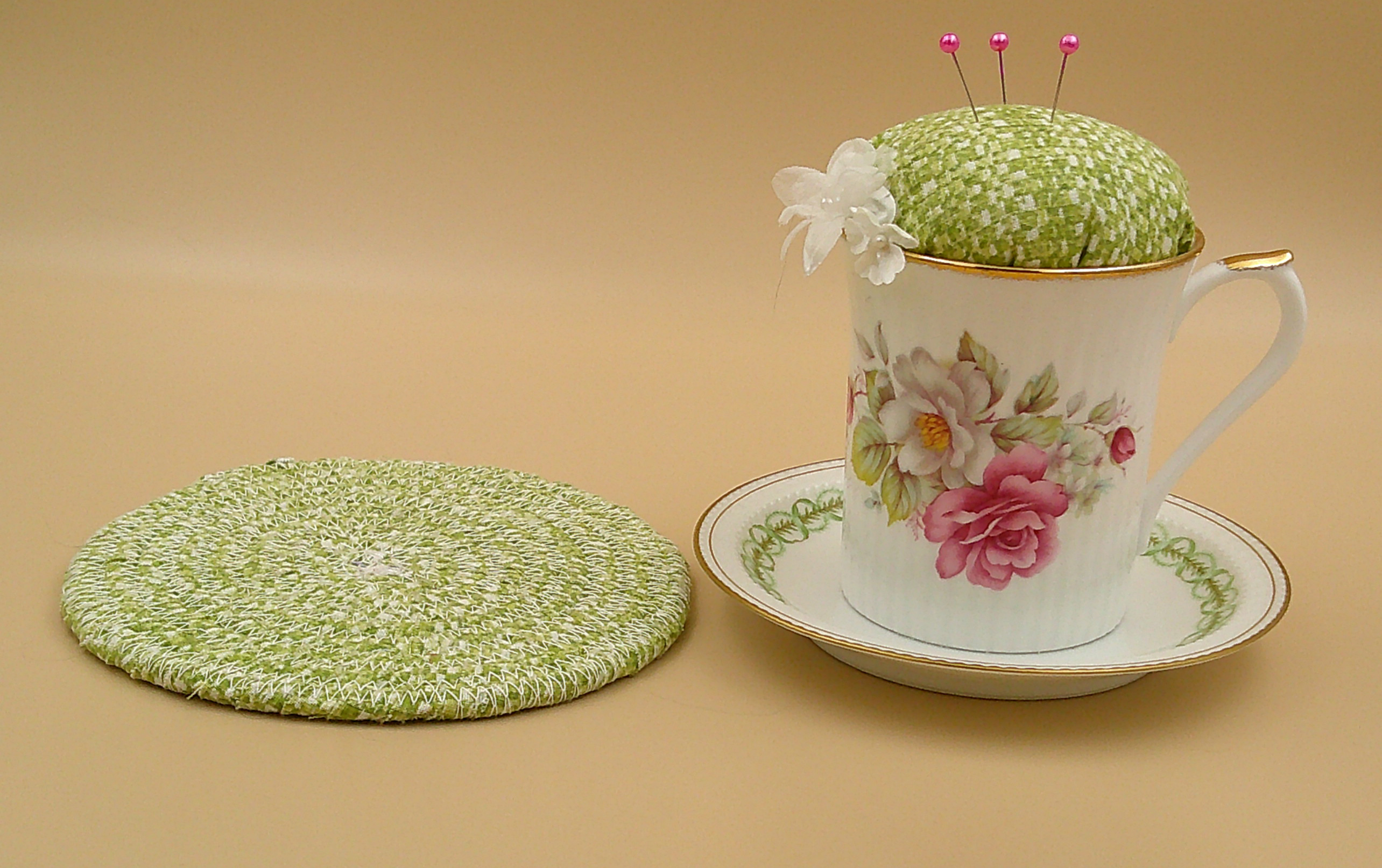 This shows the trivet next to the pincushion bobbin holder. It measures approximately 5.5 inches around. This shows the trivet next to the pincushion bobbin holder. It measures approximately 5.5 inches around.