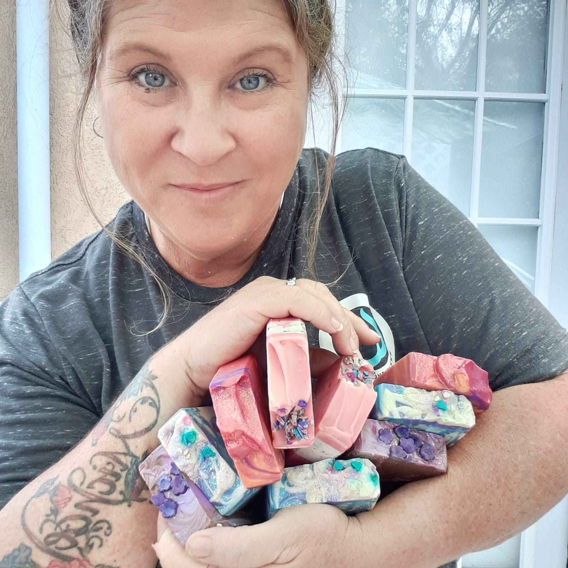 Michelle Cole holding several bars of Wash Ur Butt handmade soaps