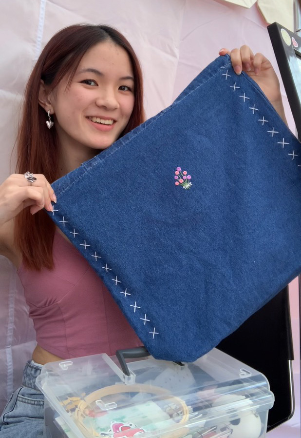 Ruby holding up the embroidered Denim Tote Bag
