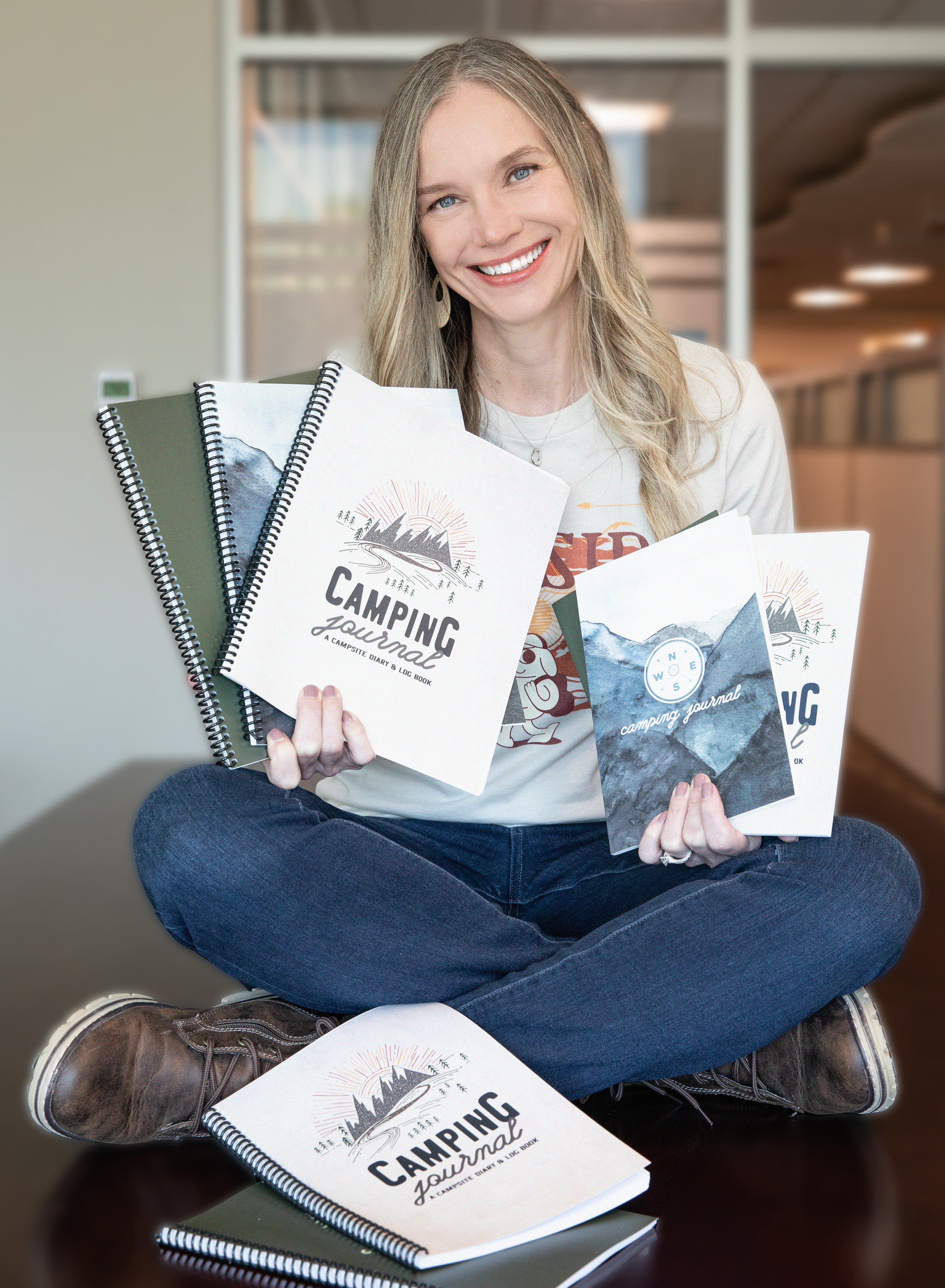 Woman holding a variety of camping journals