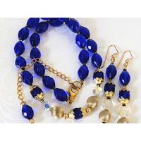Cobalt blue glass beaded necklace and earrings set, with gold tone accents. Cobalt blue glass beaded necklace and earrings set, with gold tone accents.