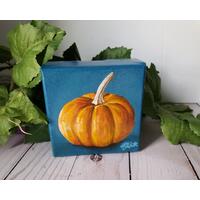 Small square painting of little orange pumpkin with teal blue background. Small square painting of little orange pumpkin with teal blue background.