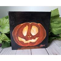 Photo of small square canvas painting of glowing jack o'lantern pumpkin with a black background Photo of small square canvas painting of glowing jack o'lantern pumpkin with a black background
