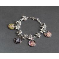 Silver bracelet with decorative balls featuring four personalized photo charms of children.  Silver bracelet with decorative balls featuring four personalized photo charms of children.
