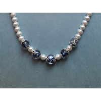 Necklace features a focal point with 5 handmade deep blue glass beads, silver bead caps around each of them, and a glass pearl in between. Necklace features a focal point with 5 handmade deep blue glass beads, silver bead caps around each of them, and a glass pearl in between.