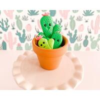 fireflyFrippery Kawaii Cactus Charms in Miniature Terra Cotta Pot on Pink Display fireflyFrippery Kawaii Cactus Charms in Miniature Terra Cotta Pot on Pink Display