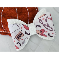 Off white glitter and faux leather print Halloween cowgirl western design hair bow. Bow is sold individually. Off white glitter and faux leather print Halloween cowgirl western design hair bow. Bow is sold individually.