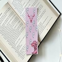 this pink western bookmark has a pink background. with a pink bull in the middle & a pink cowboy boot with a hat on top in the bottom right  this pink western bookmark has a pink background. with a pink bull in the middle & a pink cowboy boot with a hat on top in the bottom right