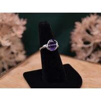 The image shows a silver ring with an amethyst double point gemstone wire wrapped with sterling silver wire. 