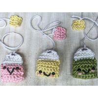 "Close-up of a cute, handmade crochet bookmark in teabag shape"
 "Close-up of a cute, handmade crochet bookmark in teabag shape"