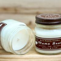 Lavender and rosemary scented soy candle in 8oz mason jar. One jar standing up with lid on and one jar on its side with lid off.