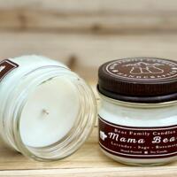 Lavender and rosemary scented soy candle in 4oz mason jar. One jar standing up with lid on and one jar on its side with lid off.